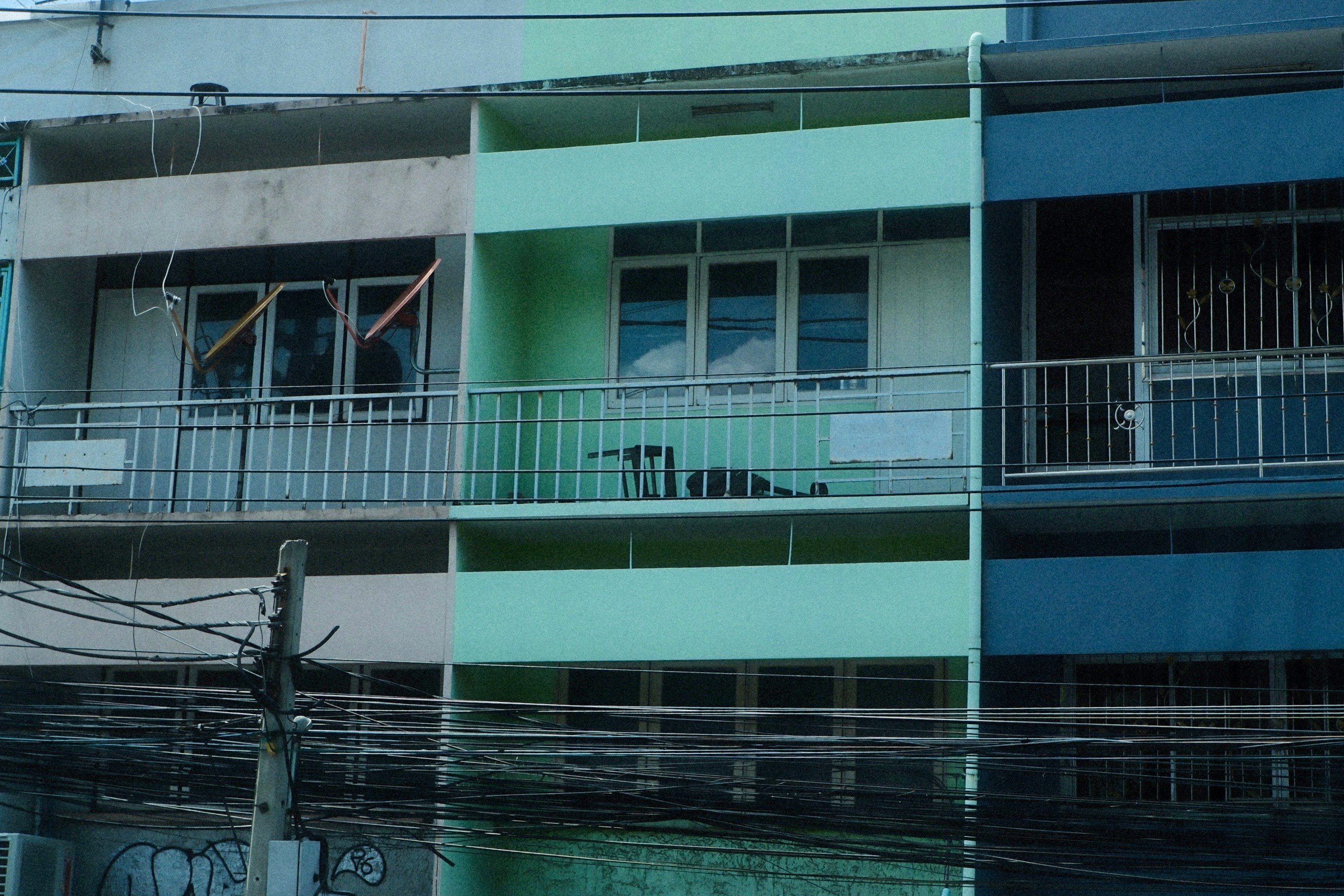 緑と白の外壁が並ぶ集合住宅の建物外観