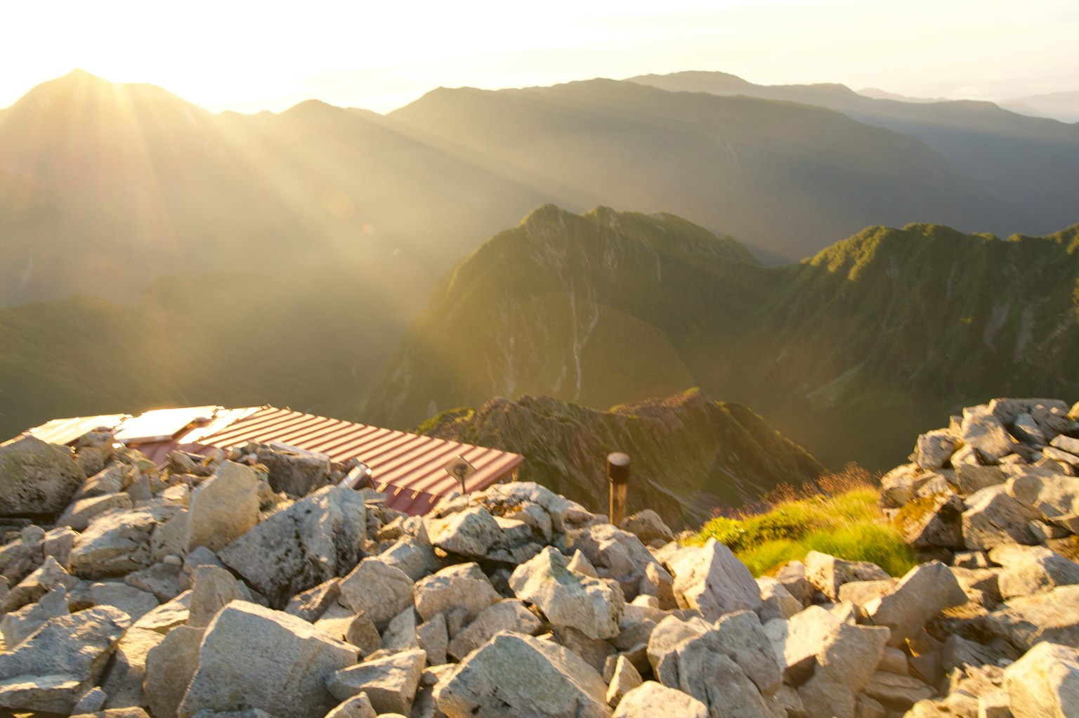 Vista panoramica da una cima montuosa illuminata dal tramonto