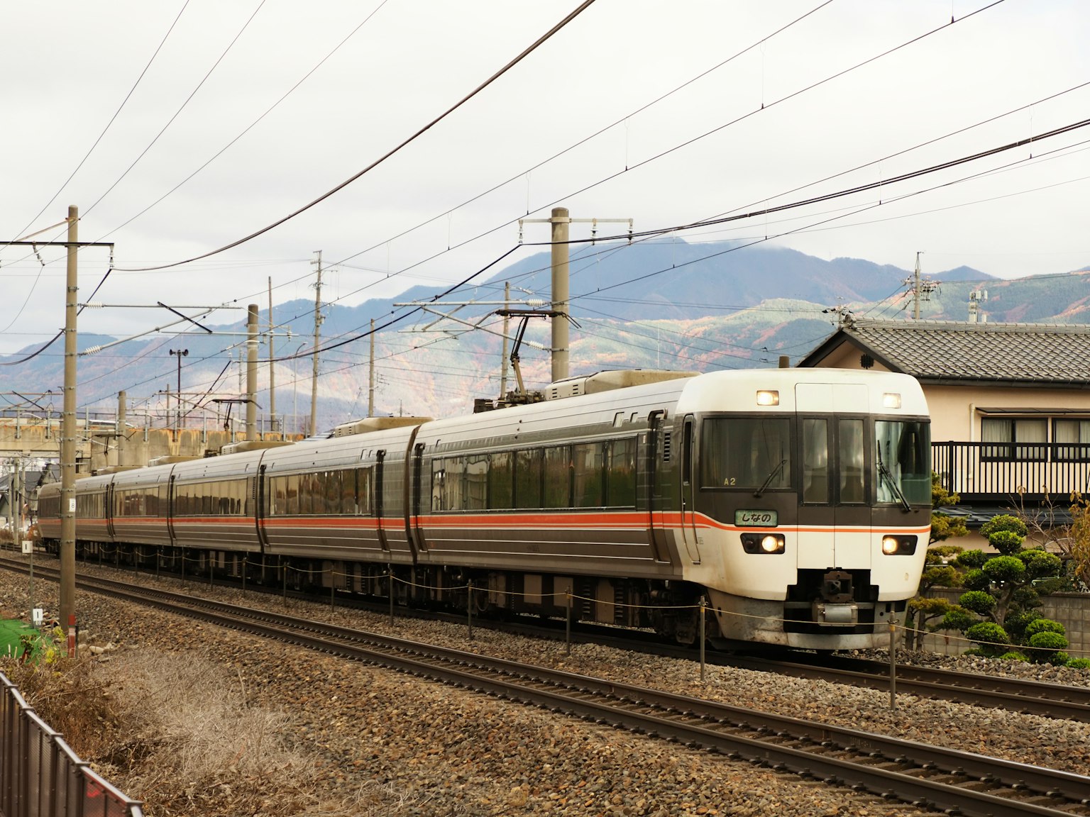 Tren expreso japonés circulando con montañas de fondo