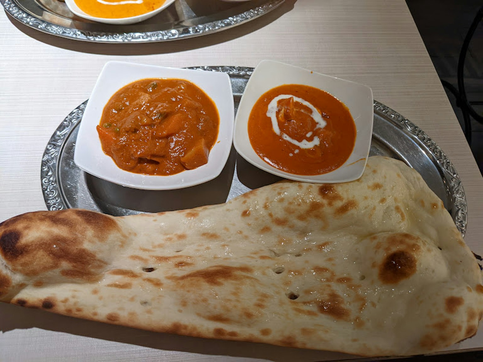 Piatto con pane naan e due tipi di curry