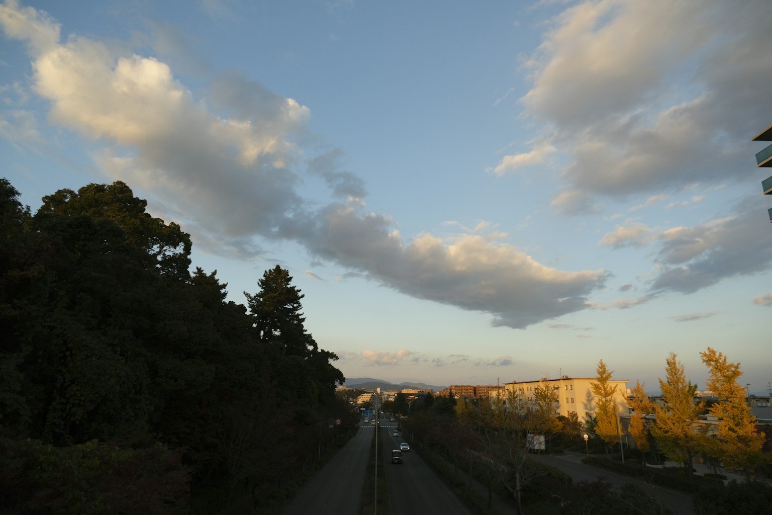 Scenic view with blue sky and white clouds distant residential area visible