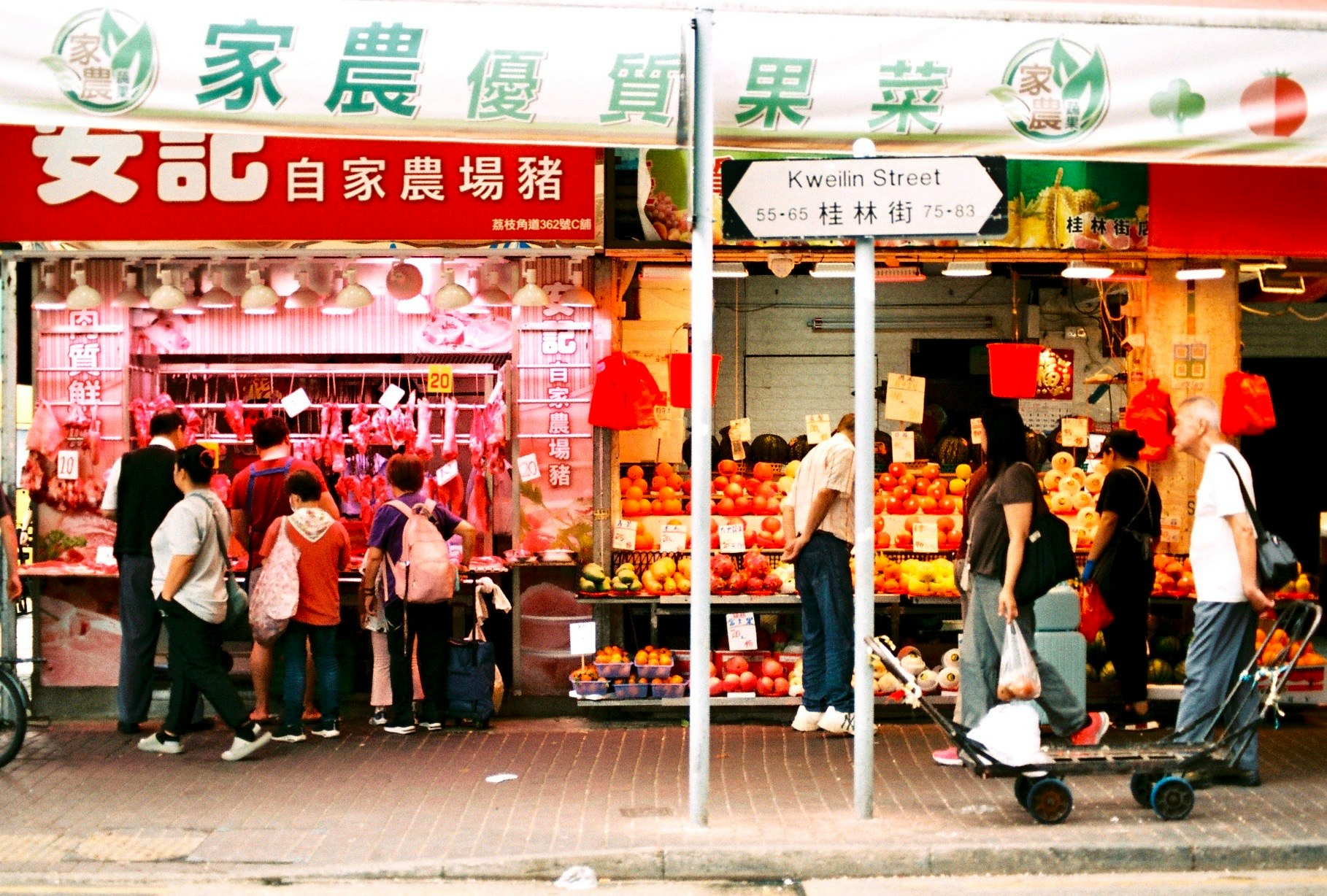 屋台の並ぶ商店街の軒先と買い物客