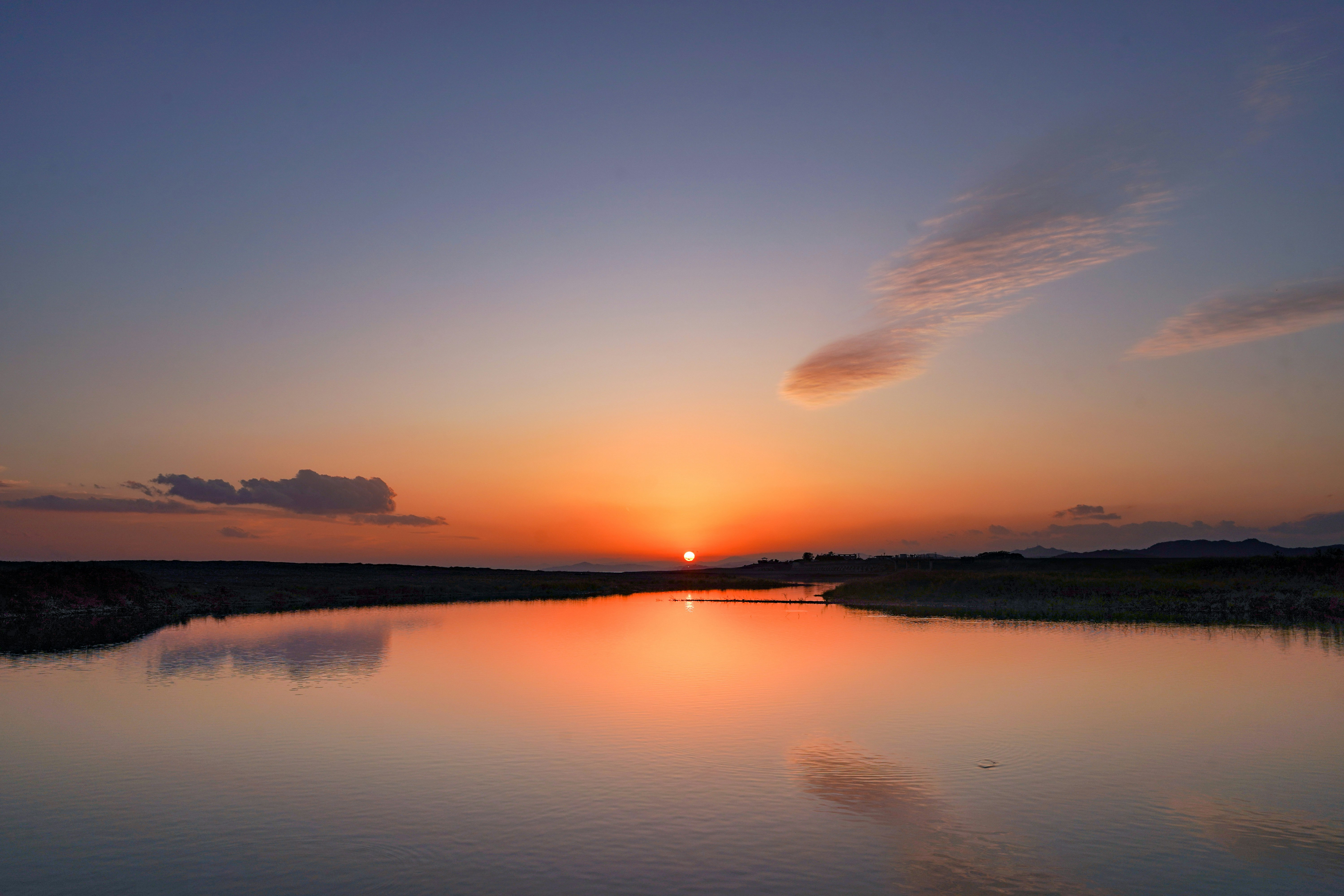 夕焼けの空と川に映る光のある風景