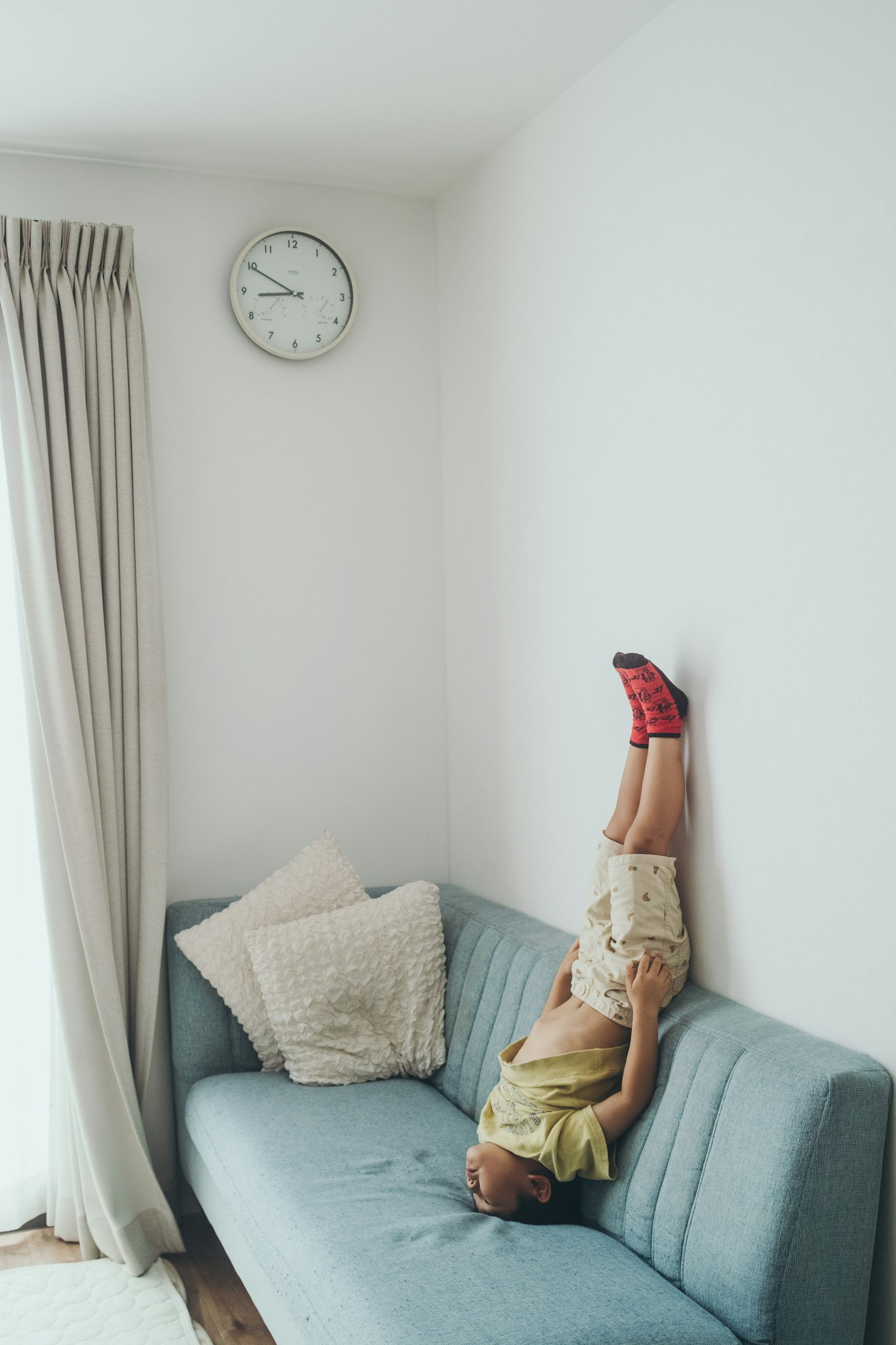 子供がソファの上で逆立ちしている部屋の内部の写真