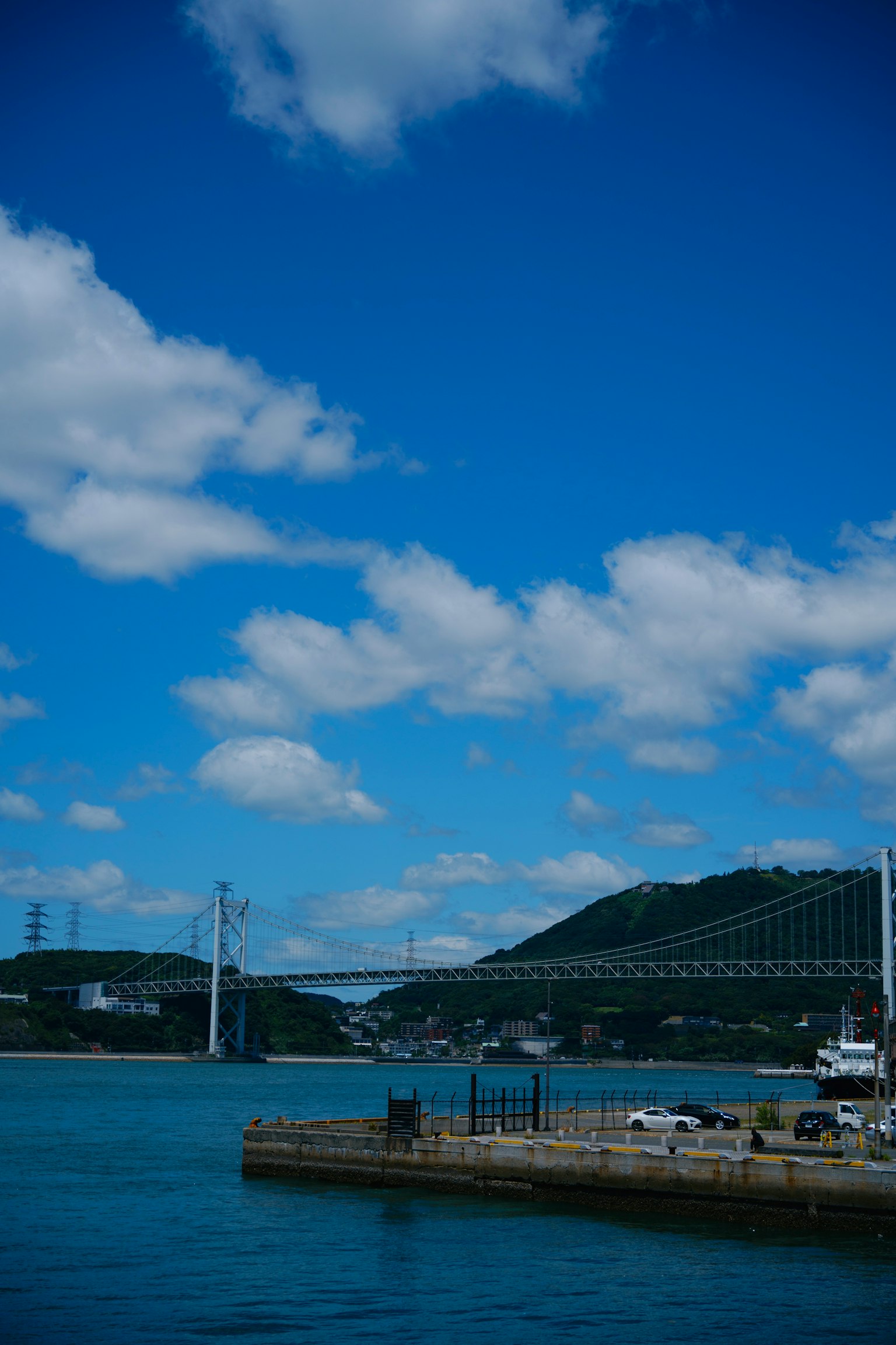 Vue panoramique d'un pont et d'un port sous un ciel bleu avec des nuages blancs
