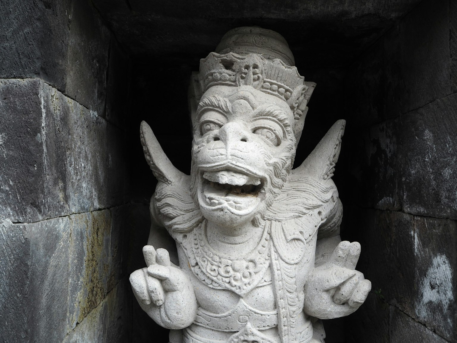 Scultura in pietra bianca di una divinità sorridente