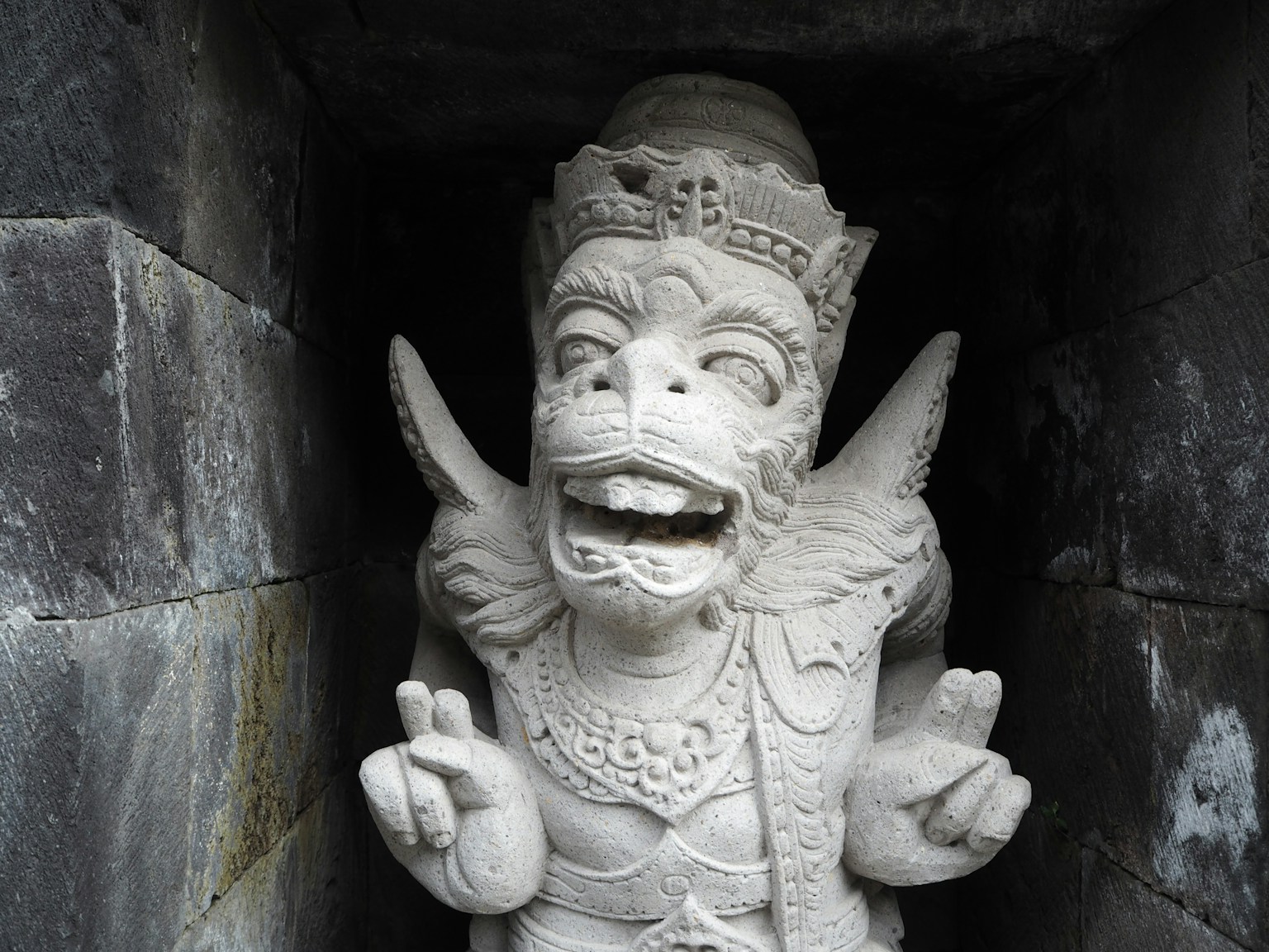 White stone sculpture of a deity smiling