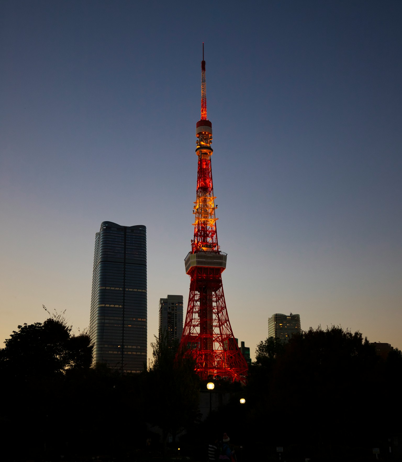 Torre di Tokyo illuminata al crepuscolo con lo skyline della città