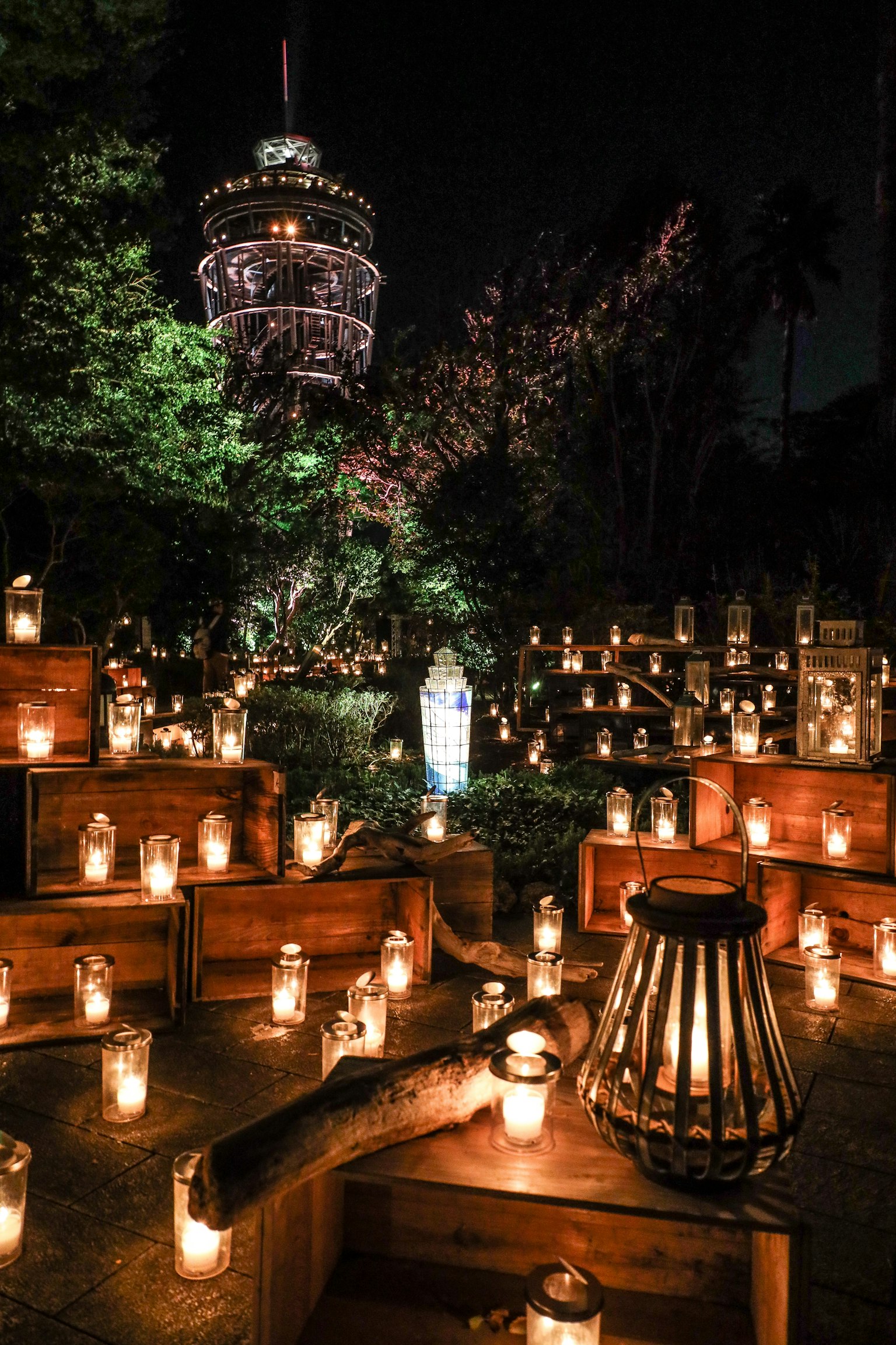 Pemandangan malam dengan lilin yang menerangi area dan menara di latar belakang