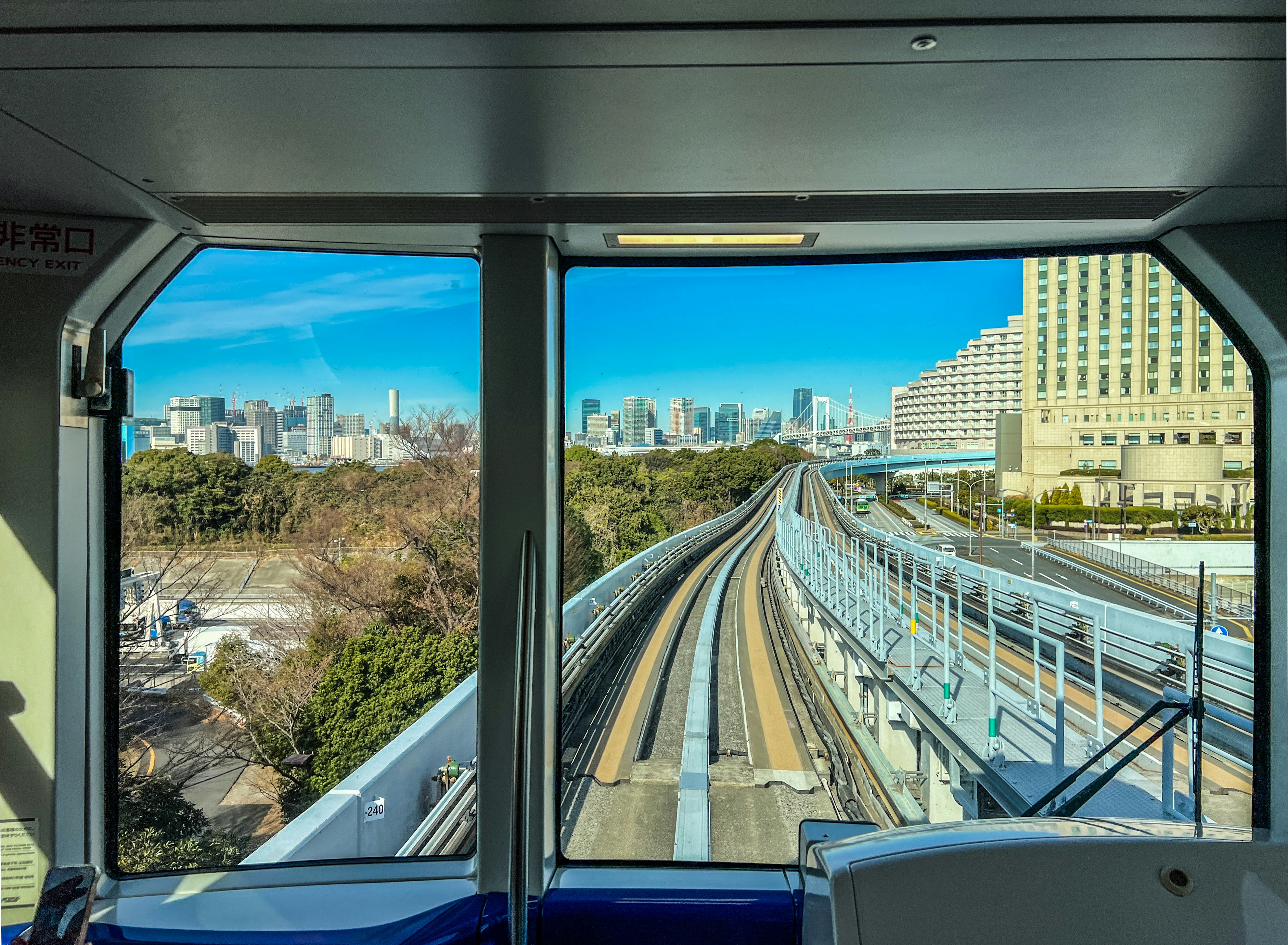 View through a window of elevated train tracks and downtown buildings