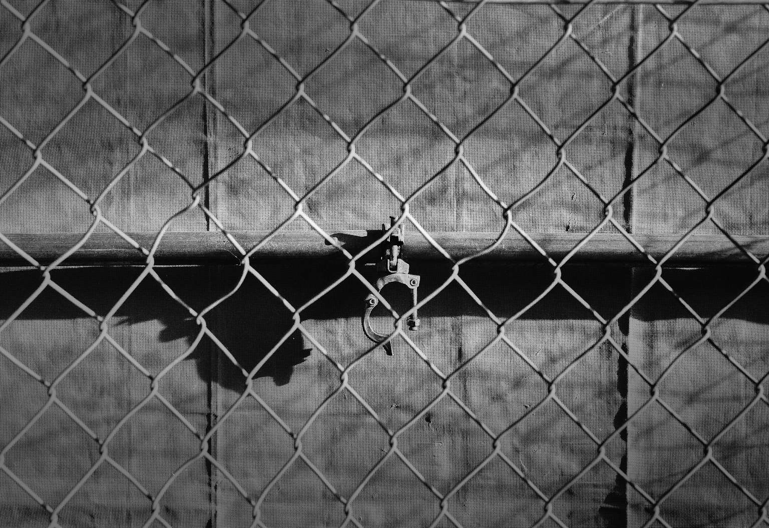 Ombre et reflets visibles à travers une clôture en treillis