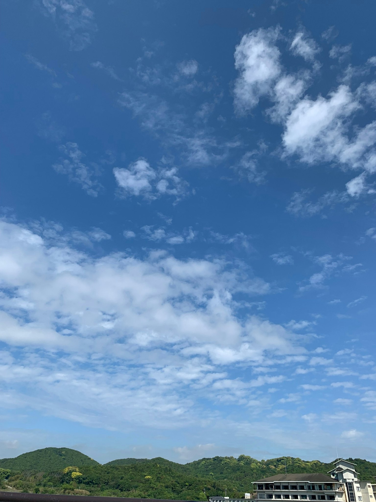 Vista escénica de cielo azul con nubes y colinas verdes