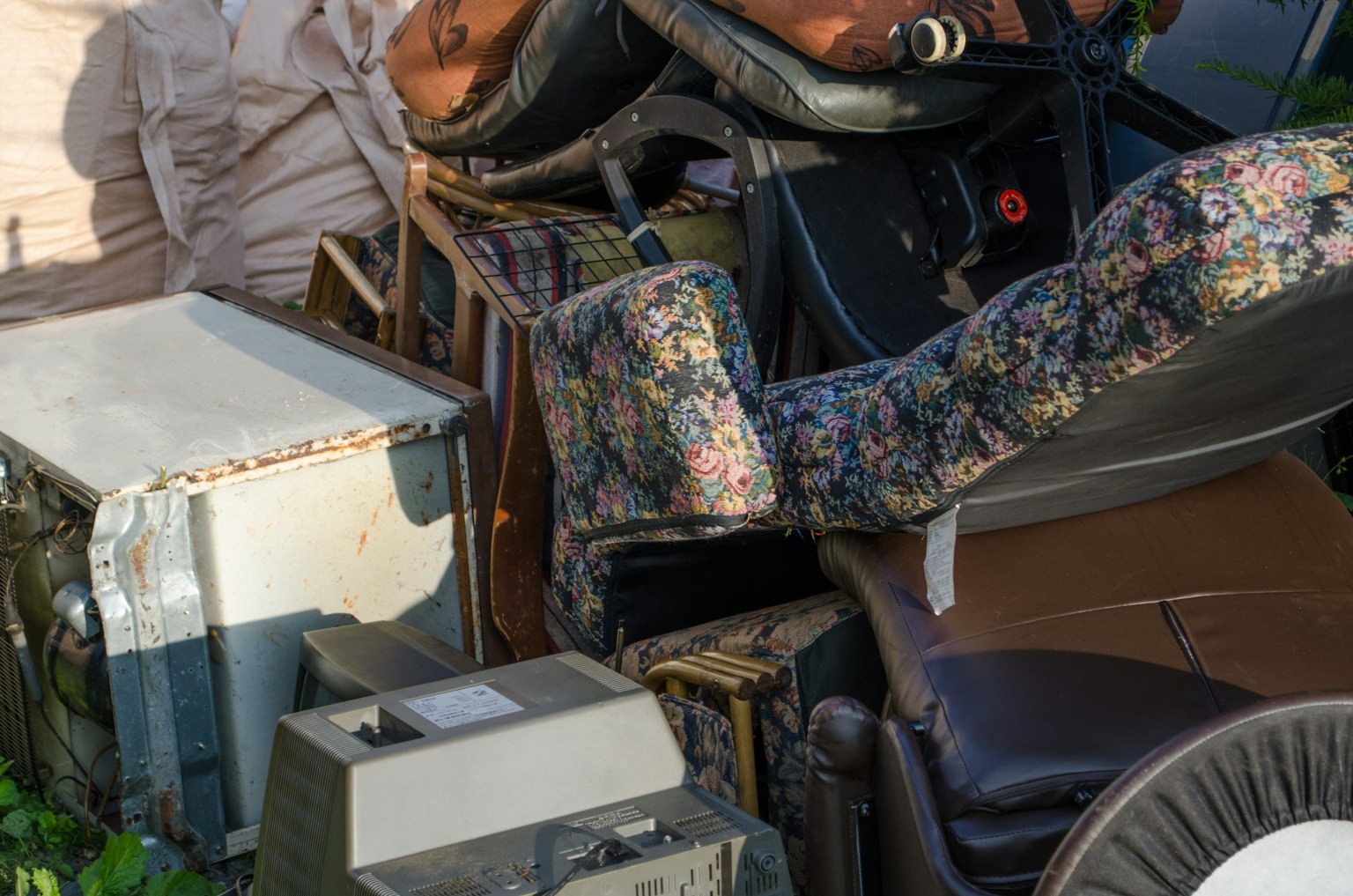 A pile of discarded furniture and appliances stacked together