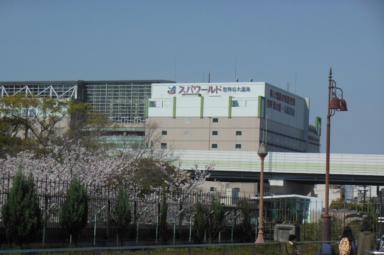 Bâtiment de supermarché avec des cerisiers en fleurs et ciel bleu