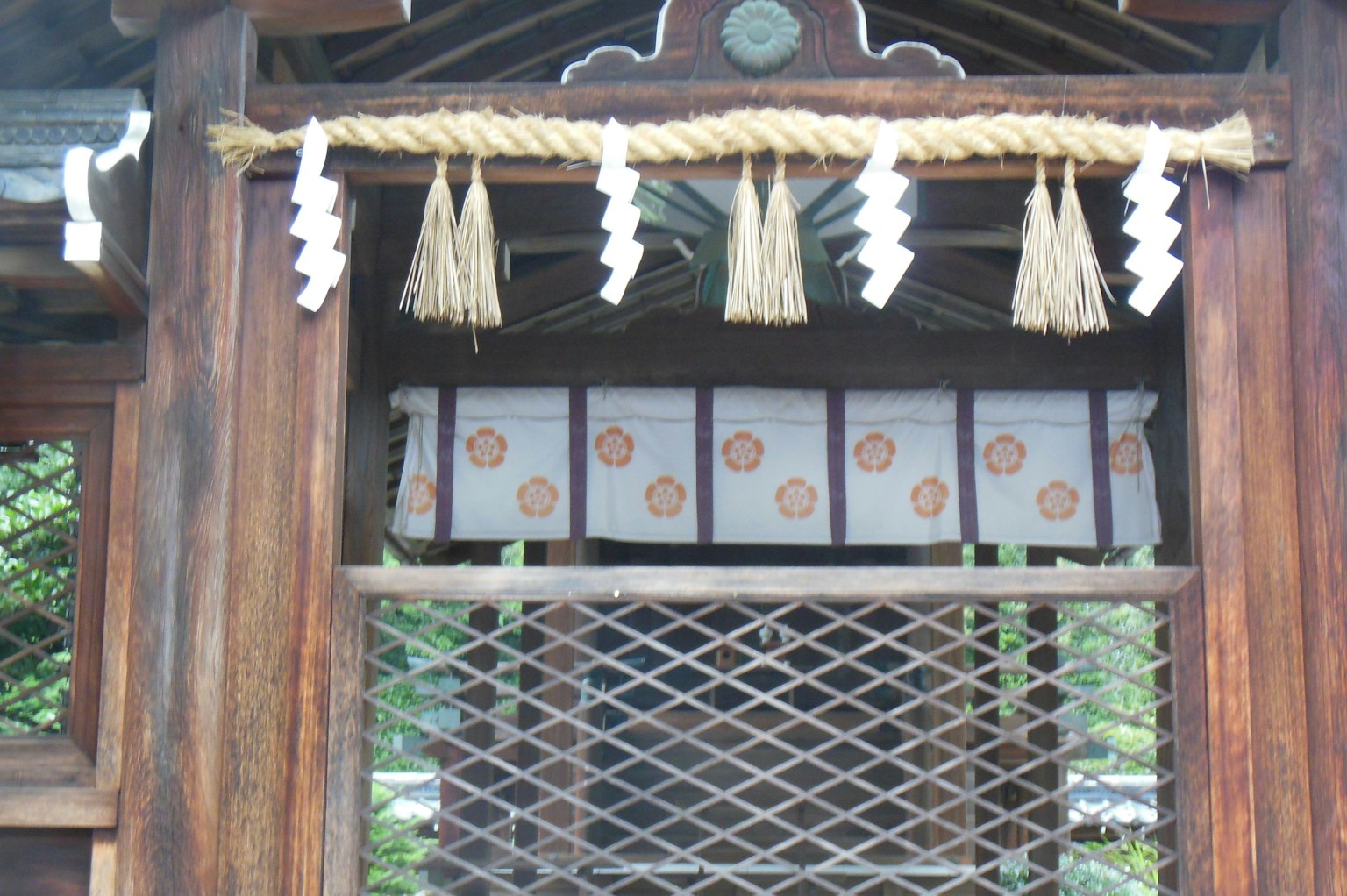 Entrada de santuario japonés tradicional con estructura de madera cuerda y decoraciones de papel blanco