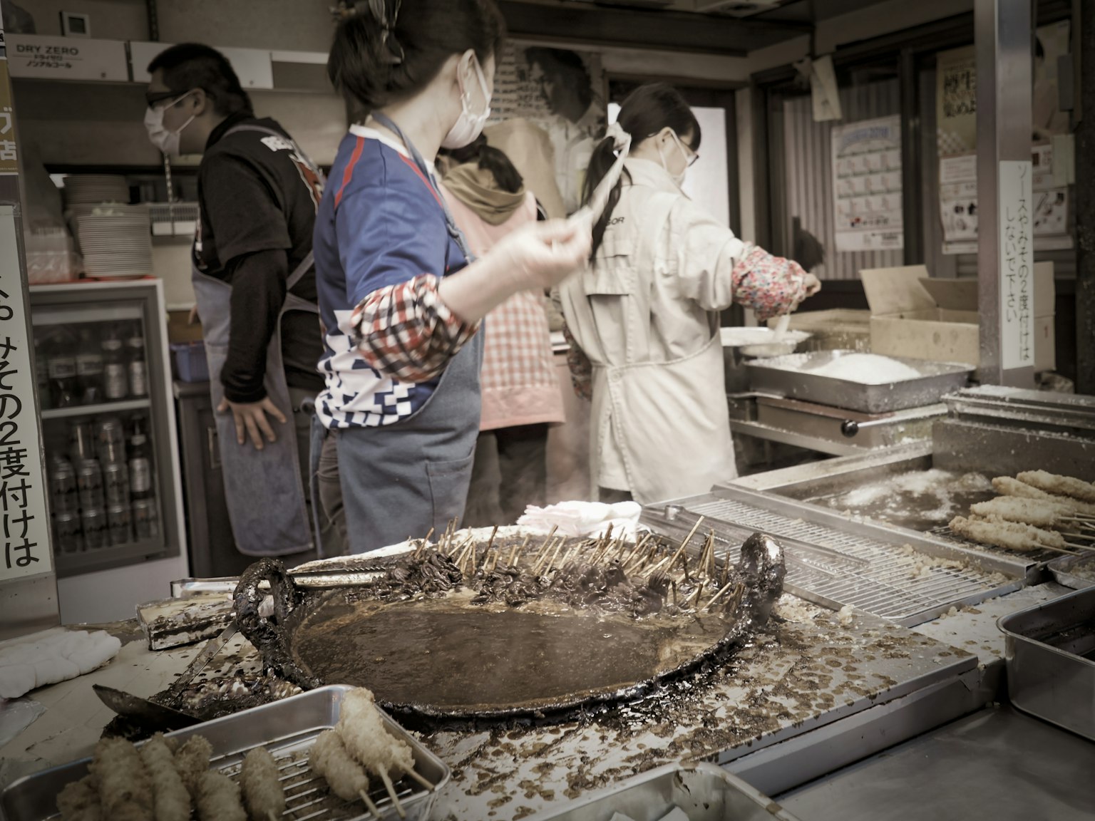 Personas preparando comida en un puesto de mercado con varios ingredientes