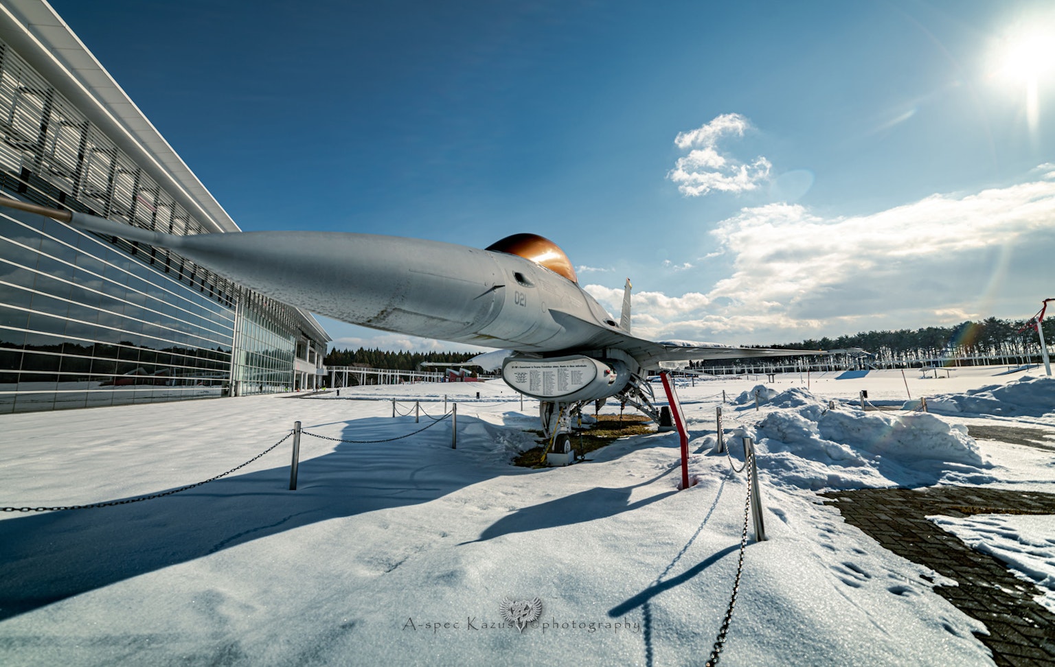 Primer plano de un avión sobre la nieve con cielo azul claro y nubes