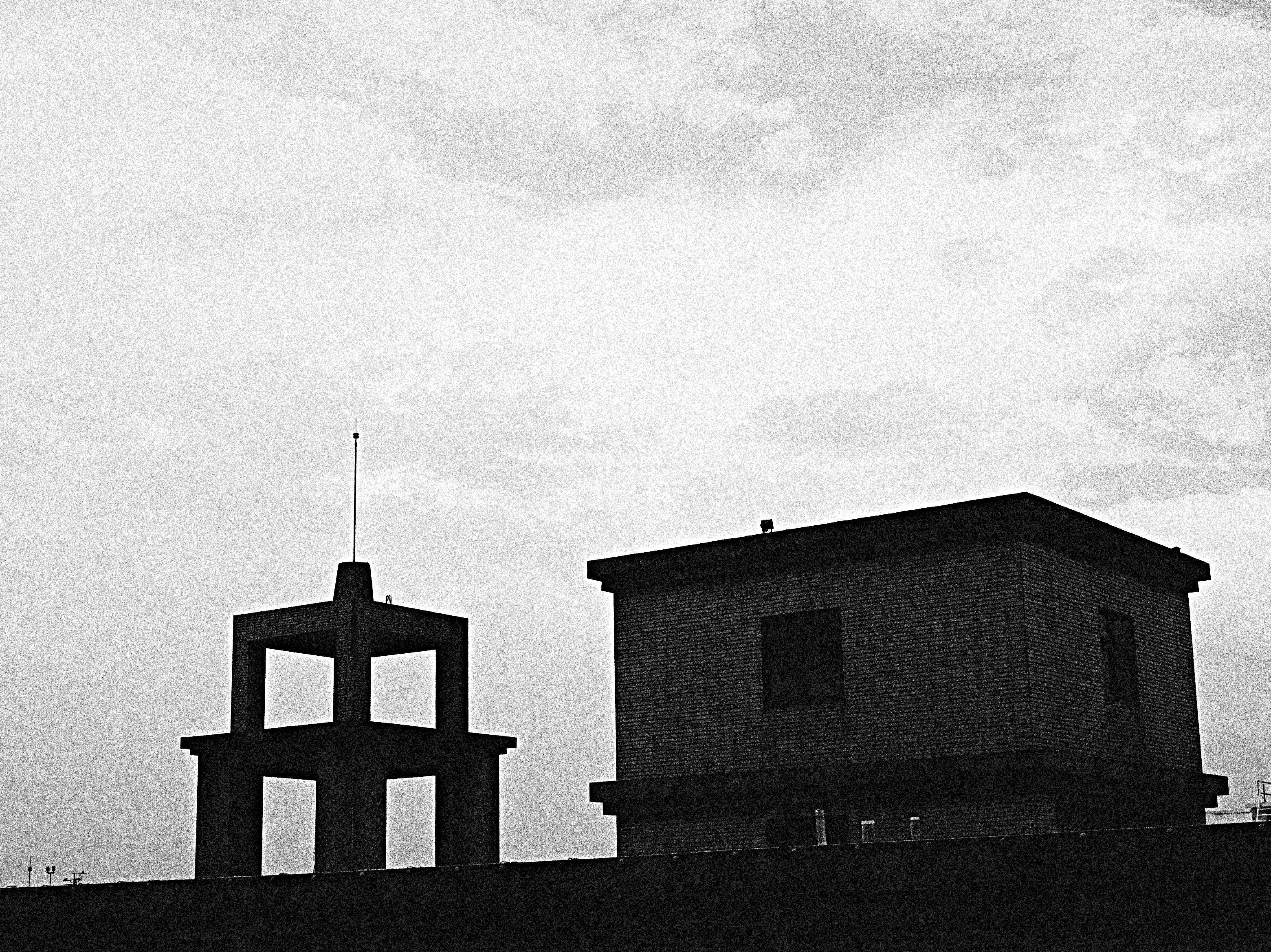 白黒の空の下に並ぶ建物の外観