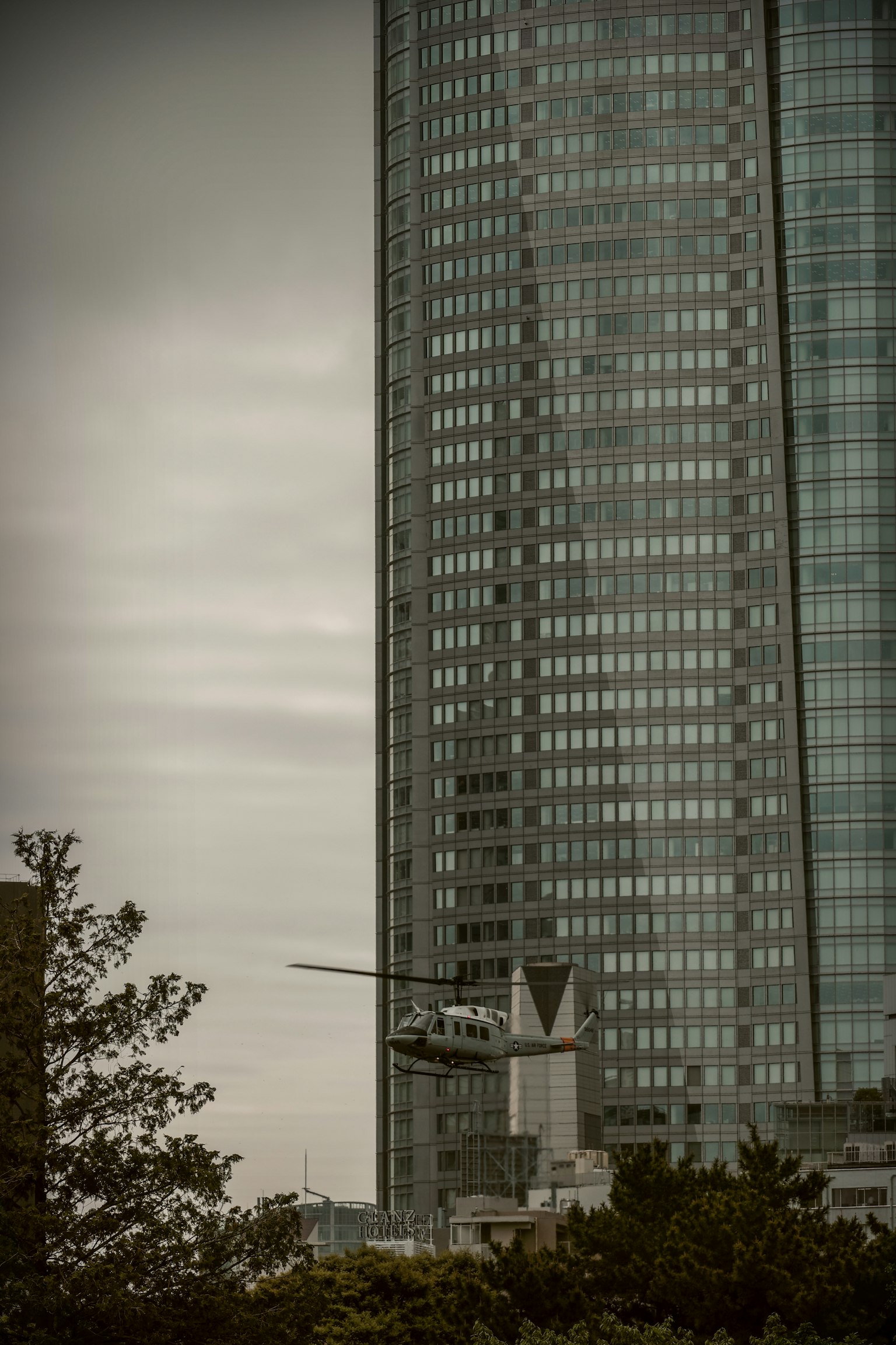 一架直升机在高楼附近,天空阴云密布