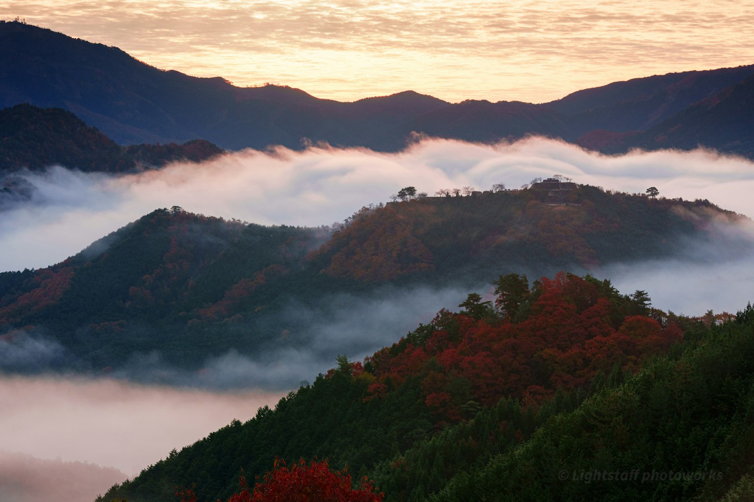 Berglandschaft in Nebel gehüllt mit lebhaften Sonnenuntergangsfarben