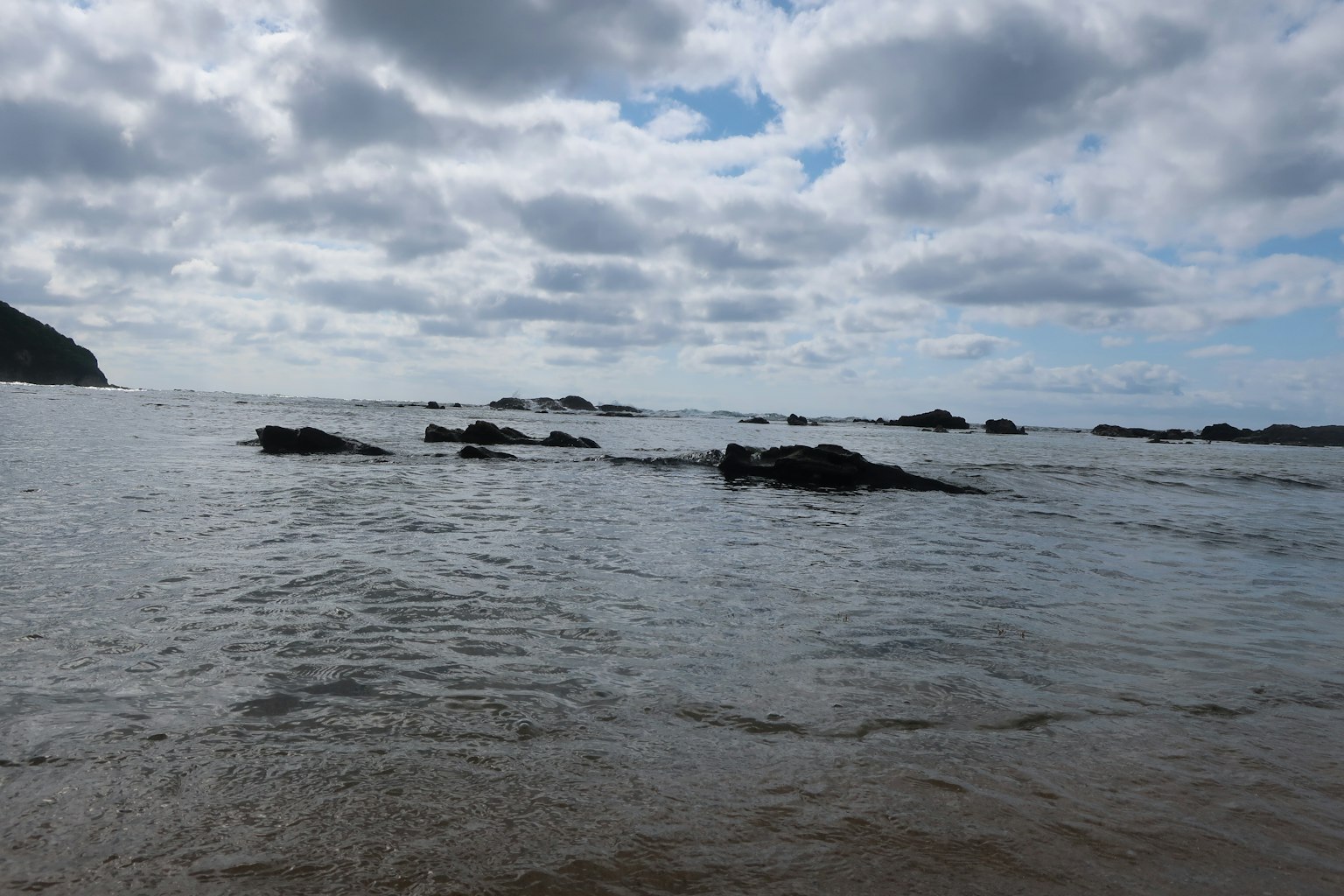 Vista escénica de una costa rocosa con olas suaves