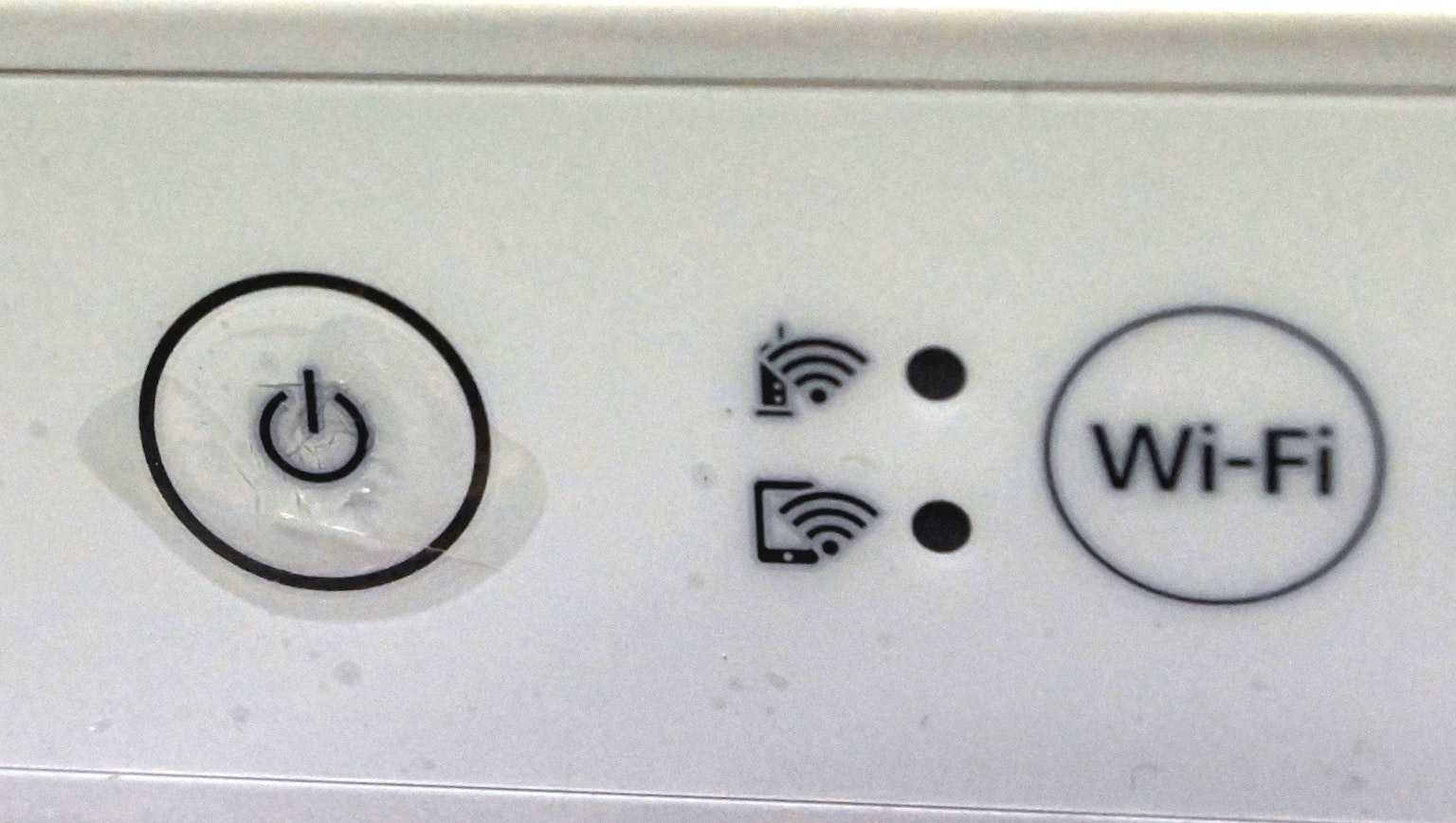 Bảng điều khiển của thiết bị màu trắng với nút nguồn và đèn báo Wi-Fi