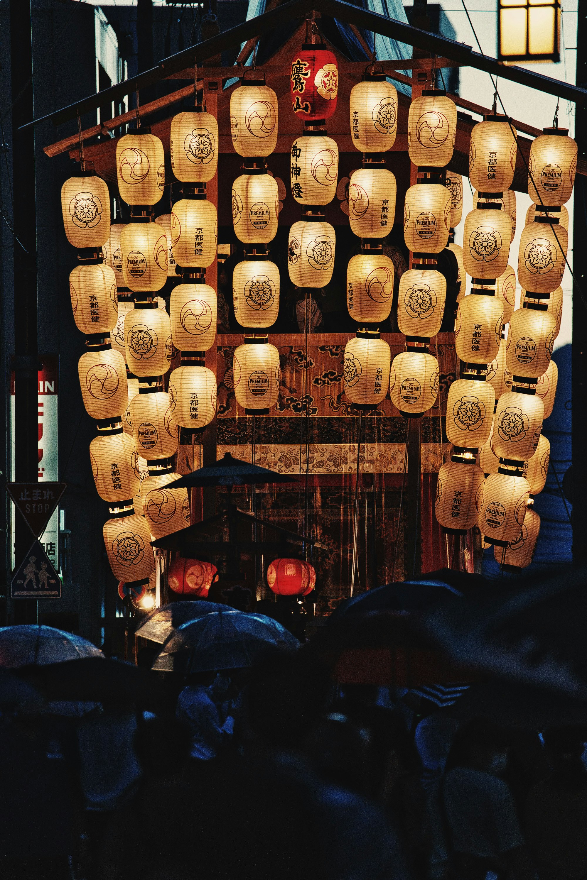 祇園祭の提灯が並ぶ雨の夜の街角