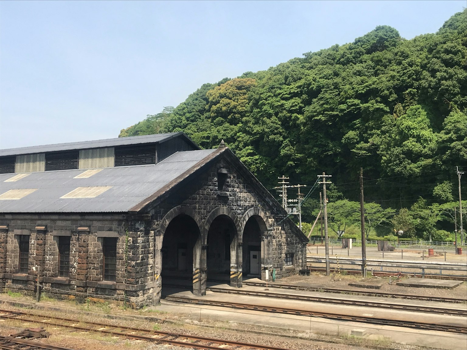 古老的石頭火車站與背景中的綠色山丘