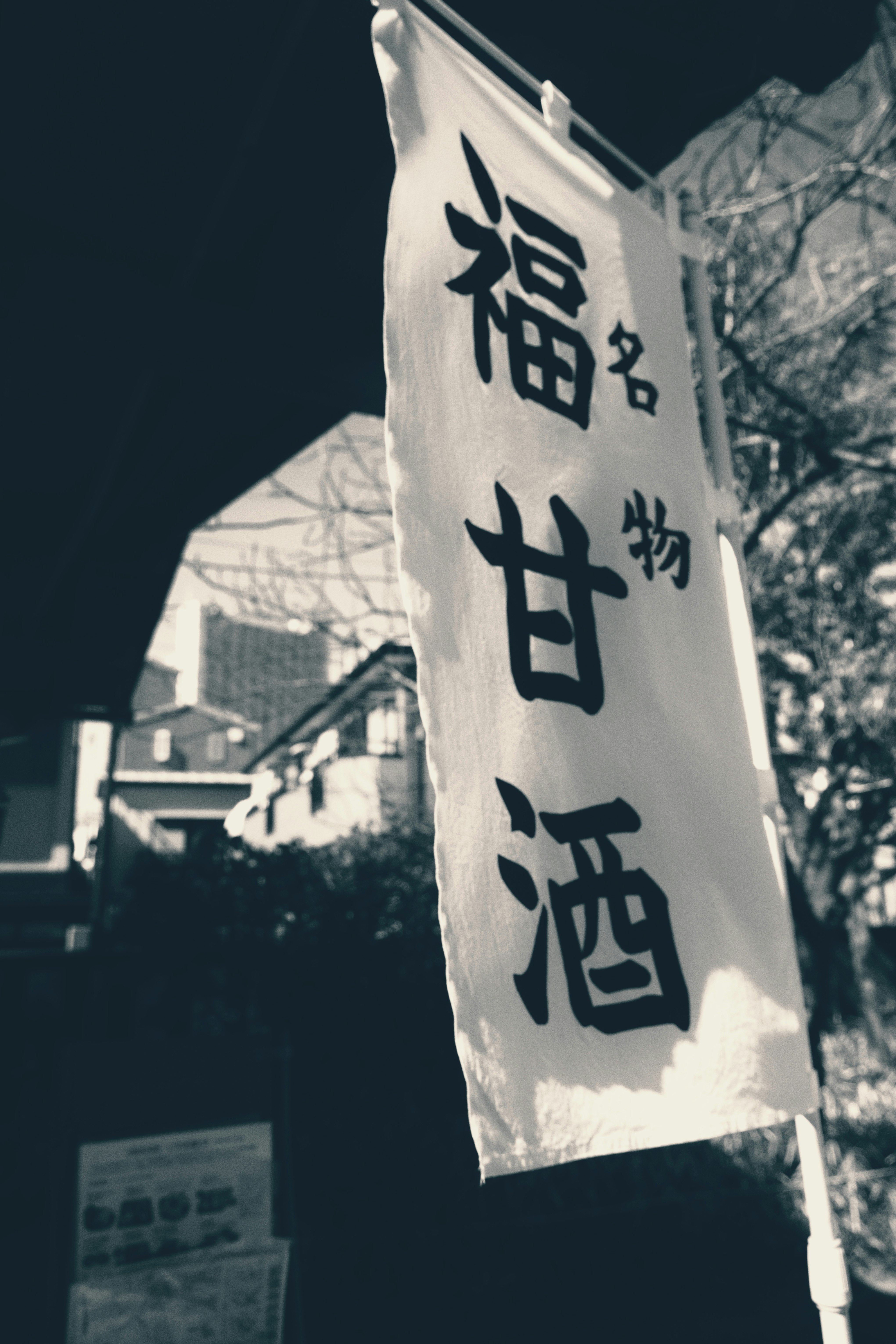 street corner with a banner flag featuring Japanese text