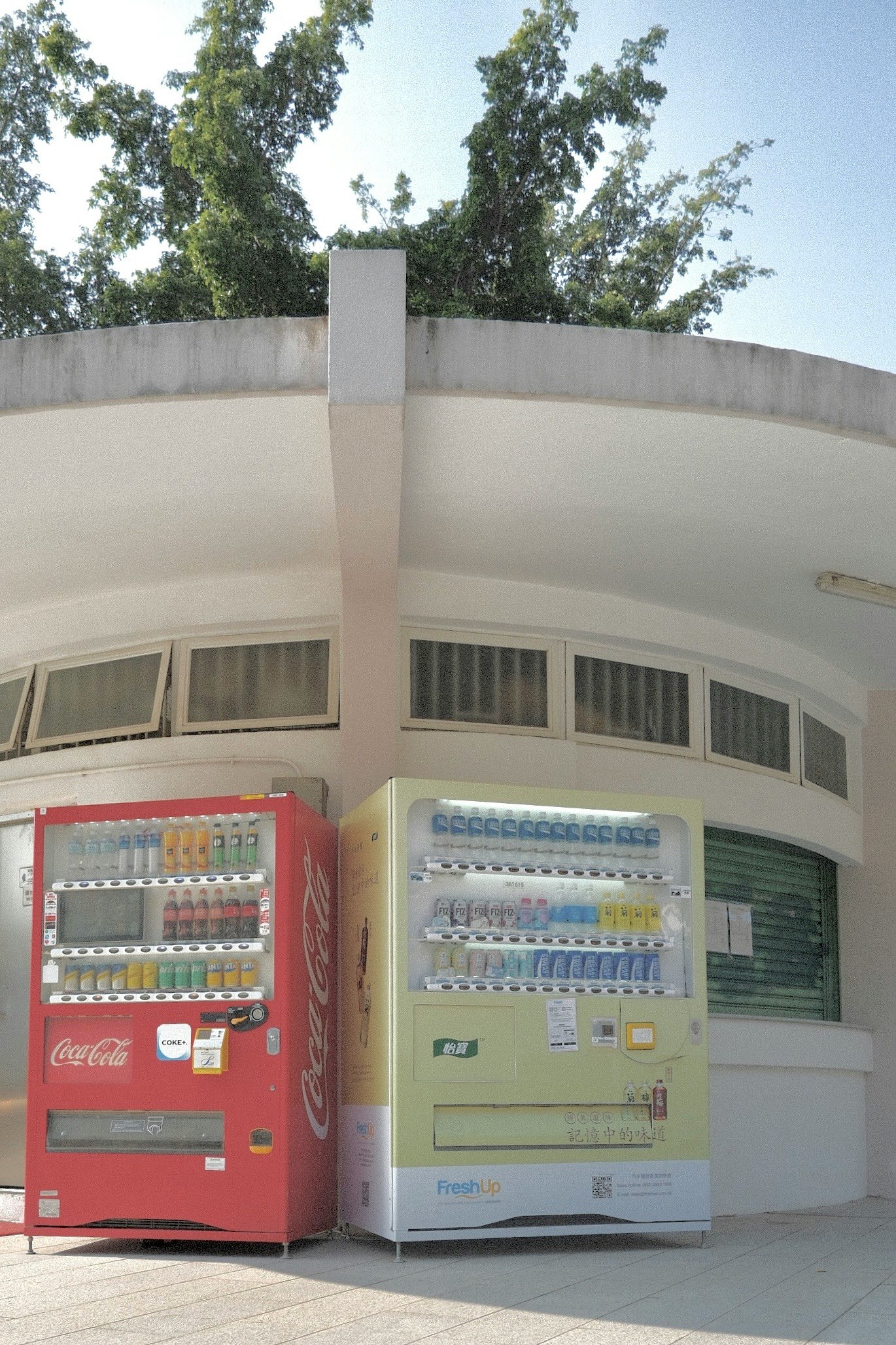 白い半円形の壁の前に並ぶ自動販売機