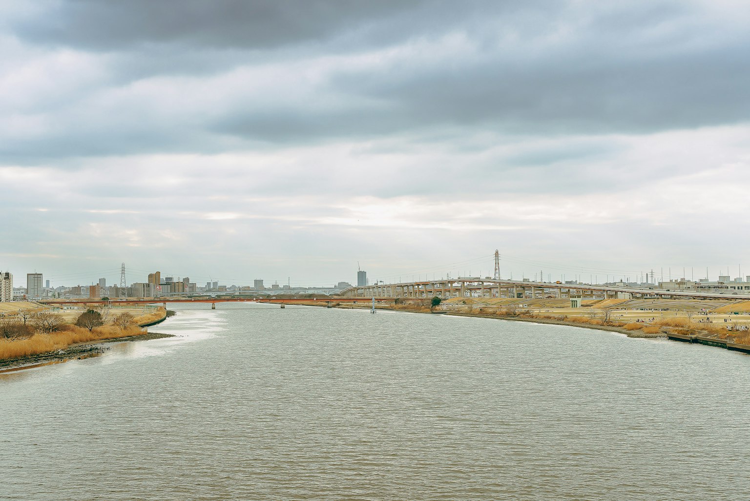 Serene river with calm water and overcast sky