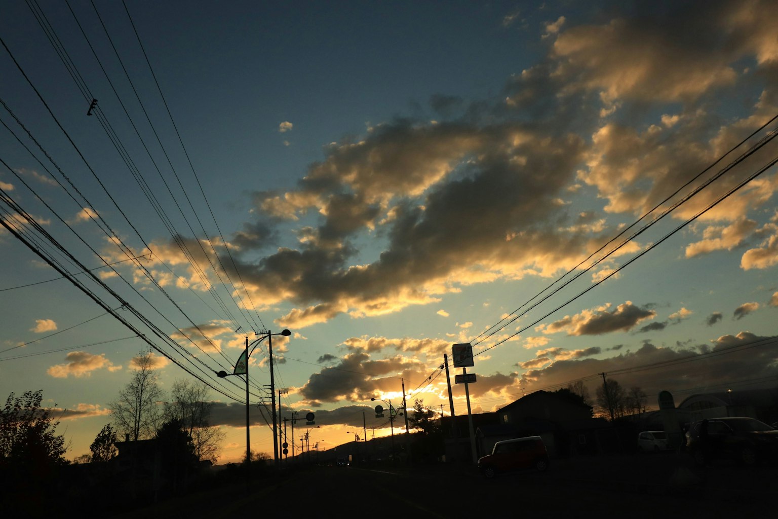 Vue panoramique d'un ciel au coucher du soleil avec des nuages et des lignes électriques