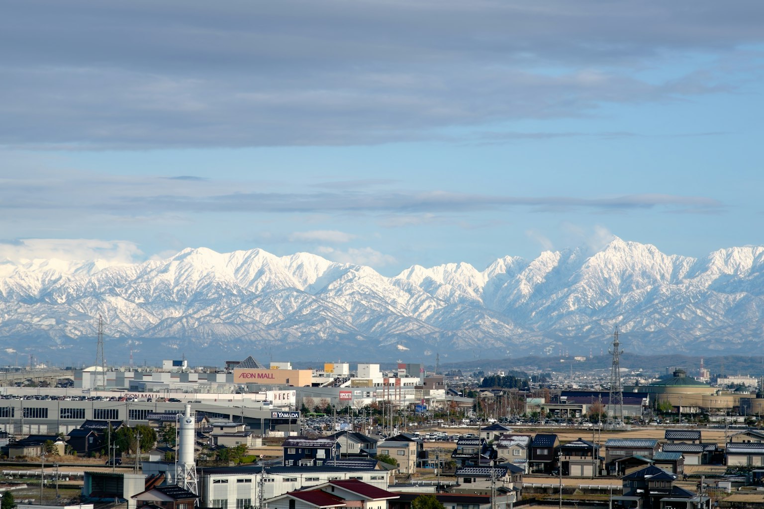 Montagne innevate che sovrastano un paesaggio urbano