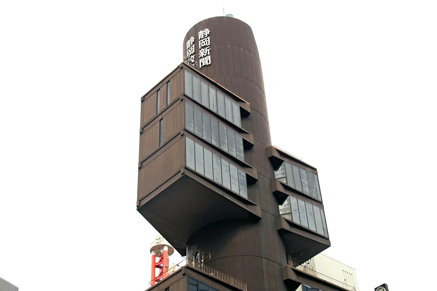 Foto di un edificio moderno con una parte superiore cilindrica e una struttura angolare sottostante