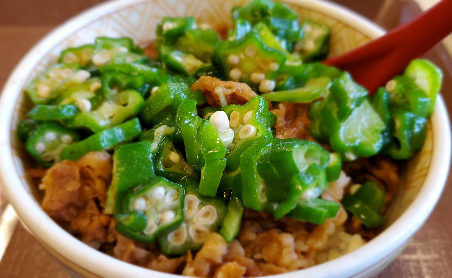 Schüssel mit Reis, belegt mit grünem Okra und Hackfleisch
