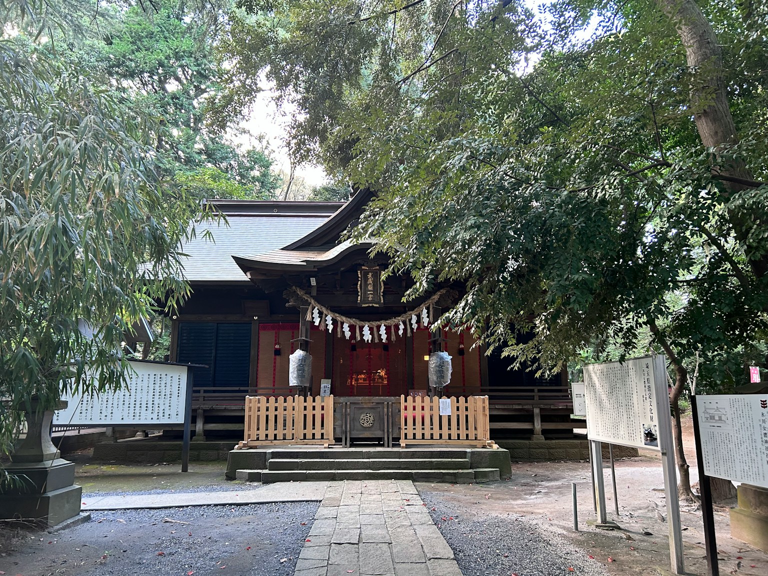 神社の正面に立つ木々に囲まれた建物