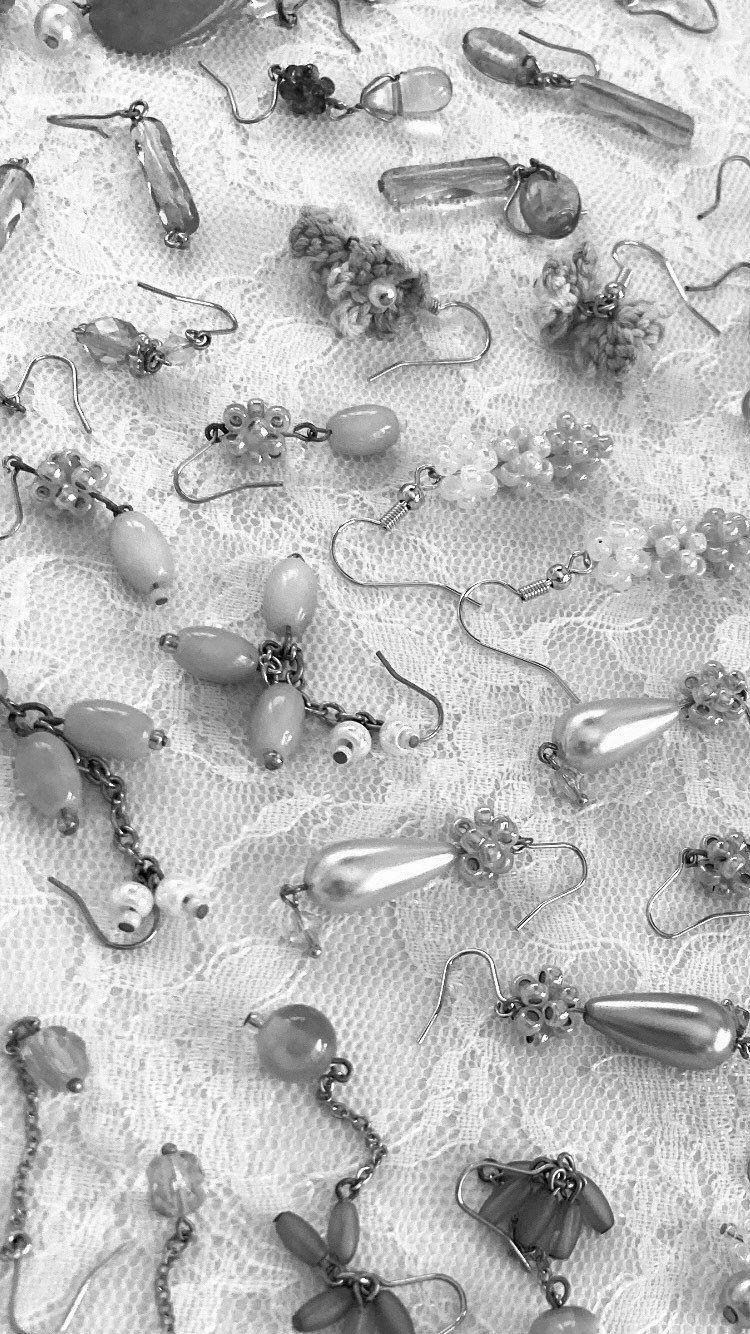 componenti di accessori e perline disposti su tessuto bianco