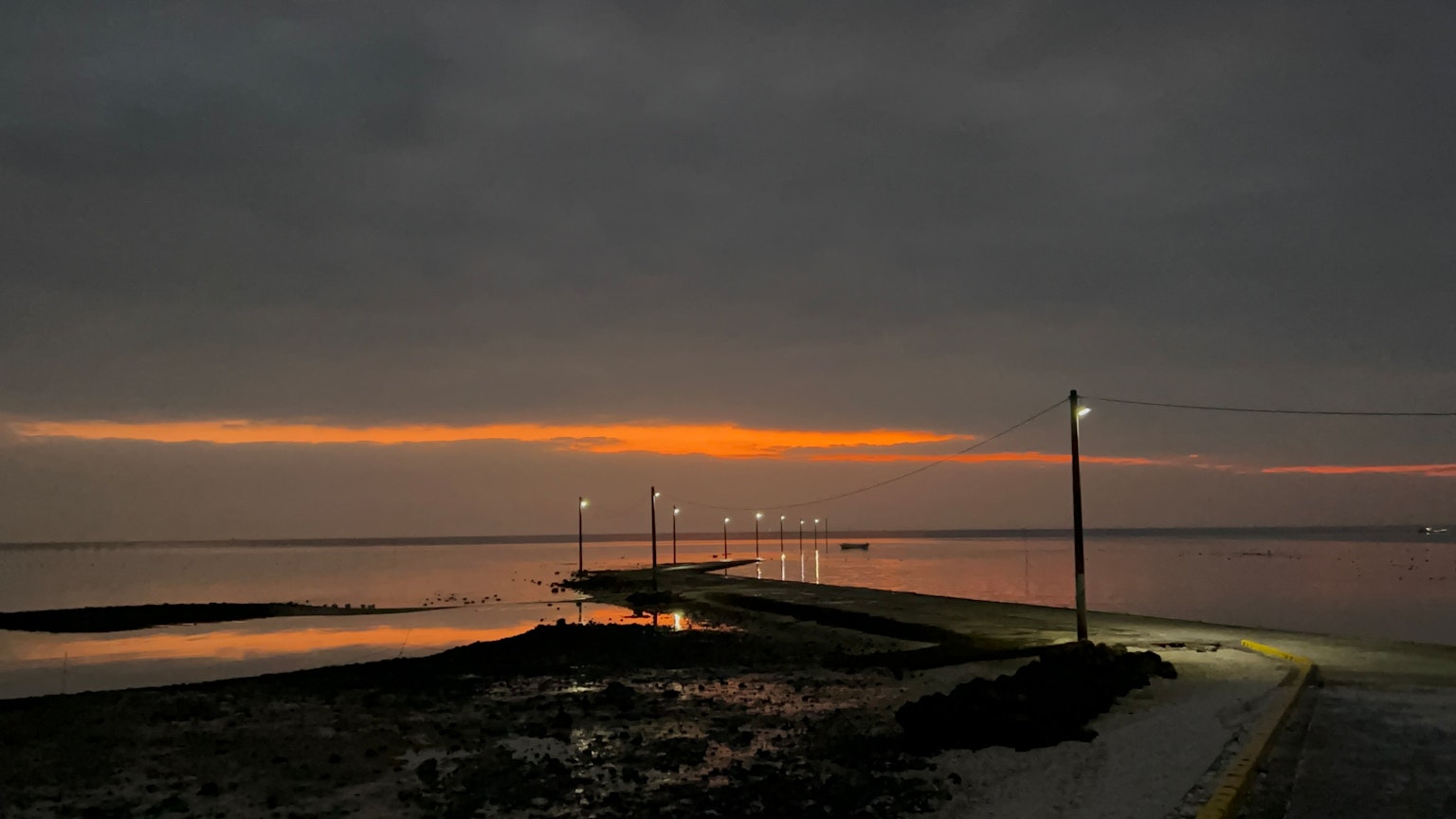 Vista panoramica di una costa al tramonto con luci