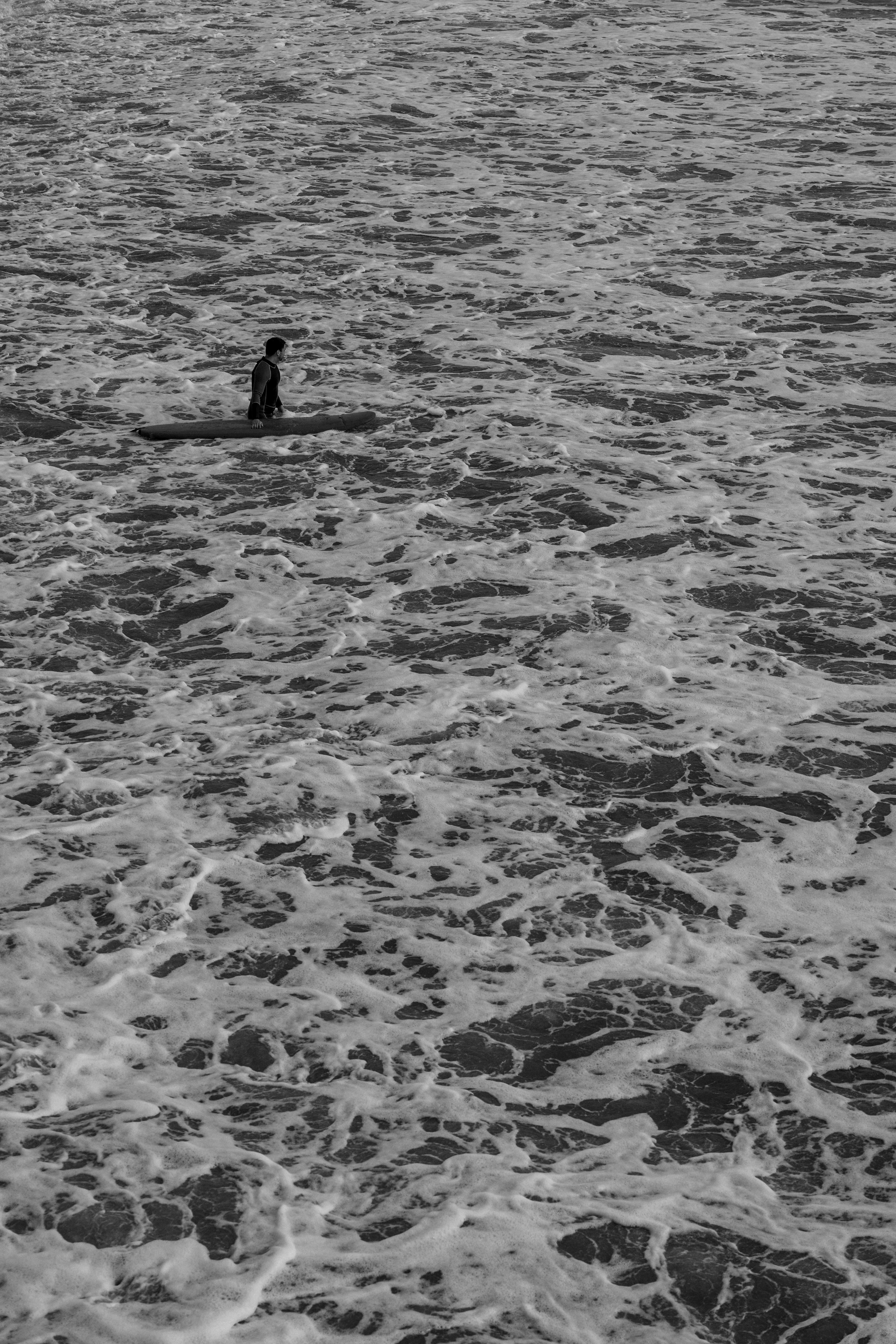 Black and white photo of a person surfing in the ocean waves