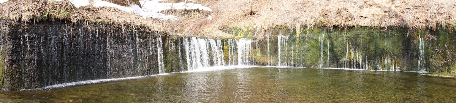 Paesaggio naturale con cascate e superficie d'acqua calma