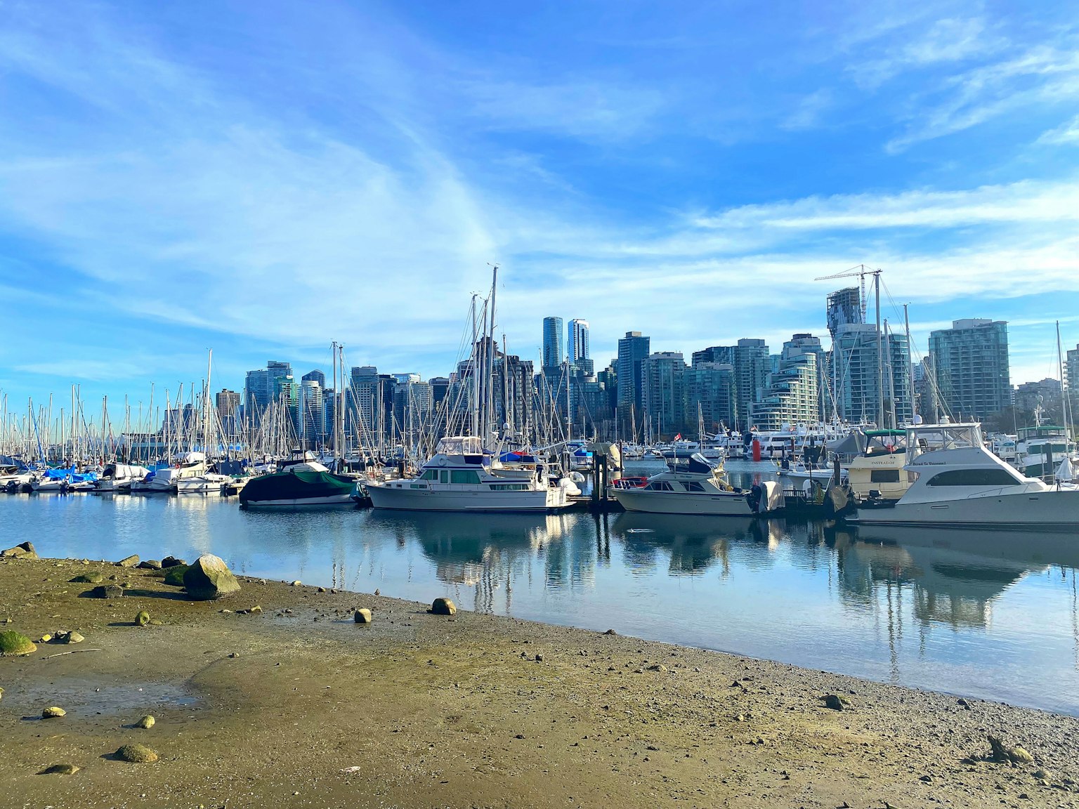 Botes atracados cerca de la playa con el horizonte de Vancouver al fondo