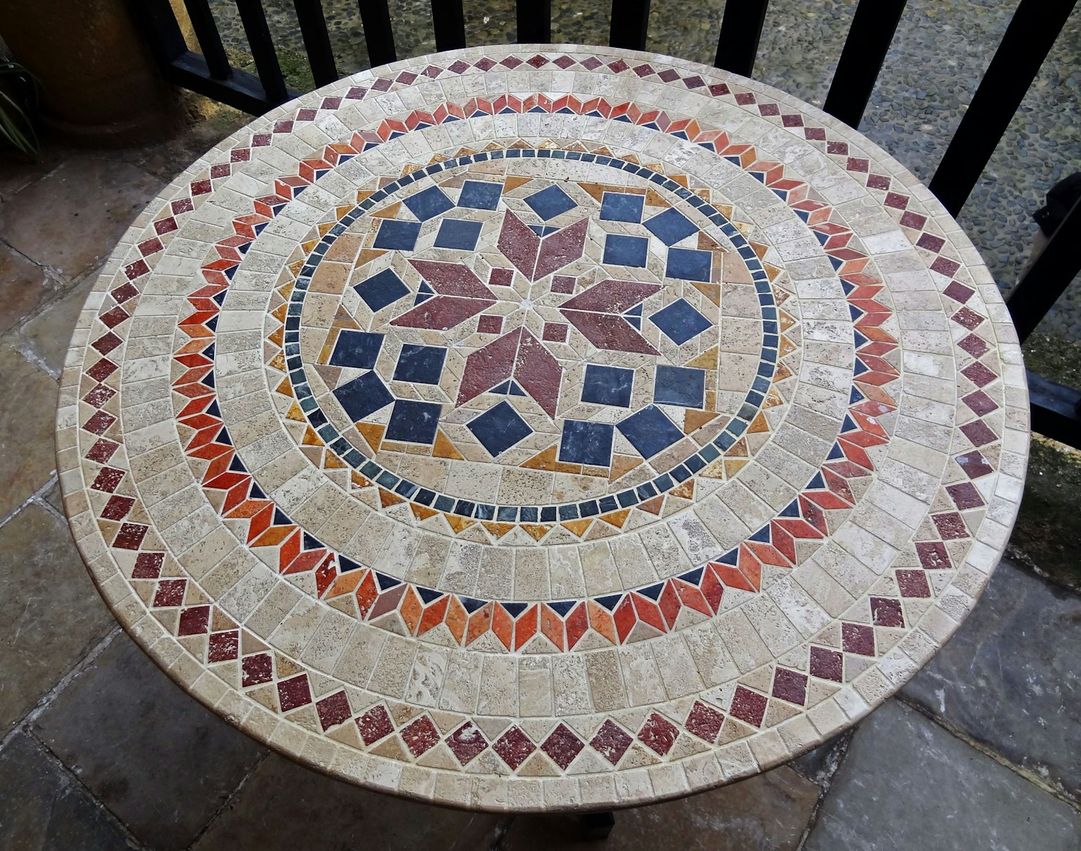 Desain rinci meja mosaik bulat dengan warna cerah dan pola geometris