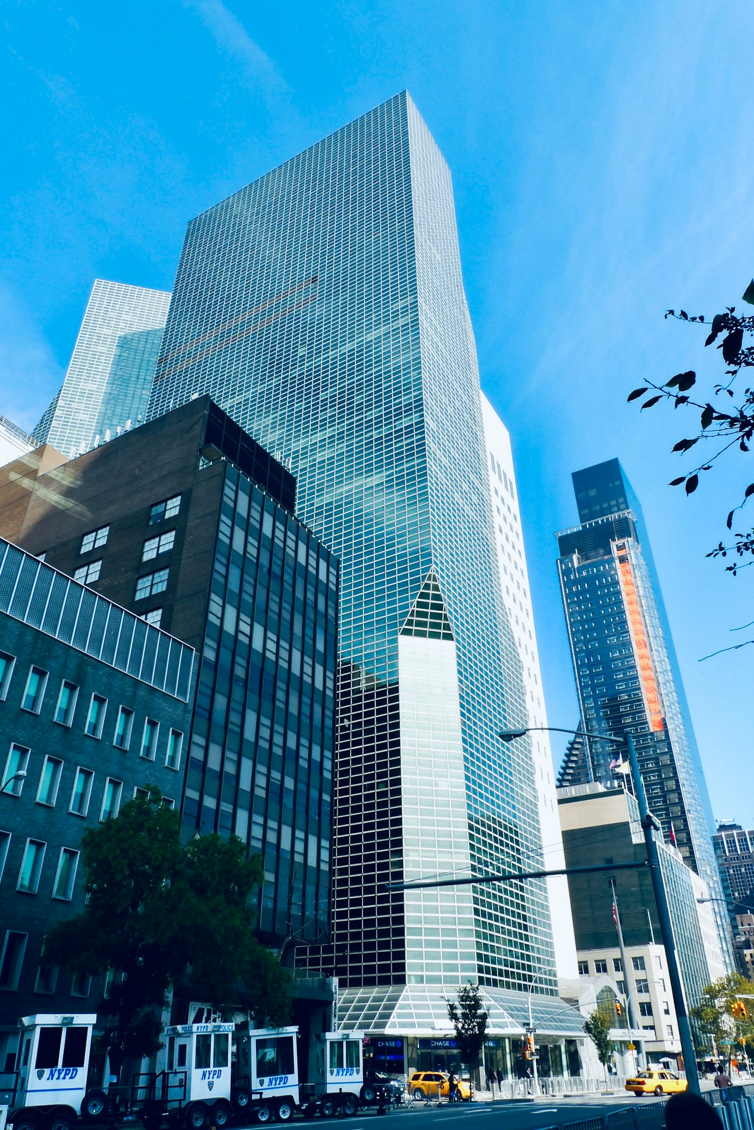 Cityscape featuring tall buildings bright blue sky and glass reflections
