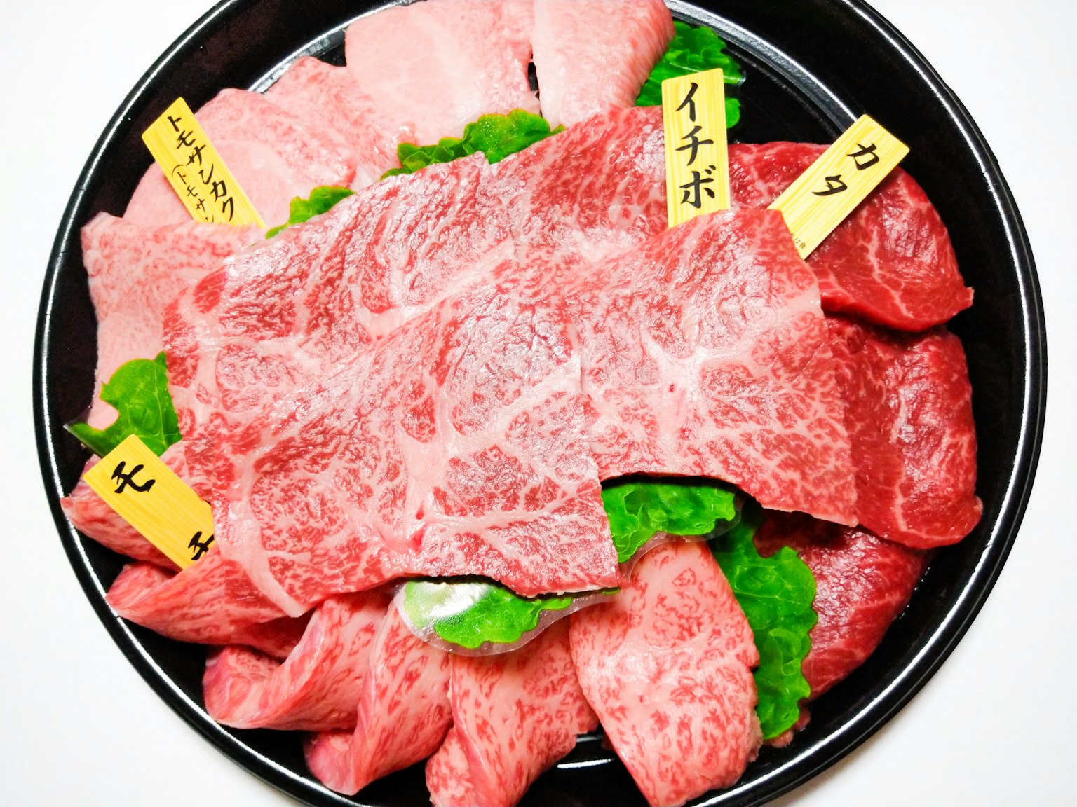 Bunt gemischte Wagyu-Rindfleischscheiben auf einem Teller