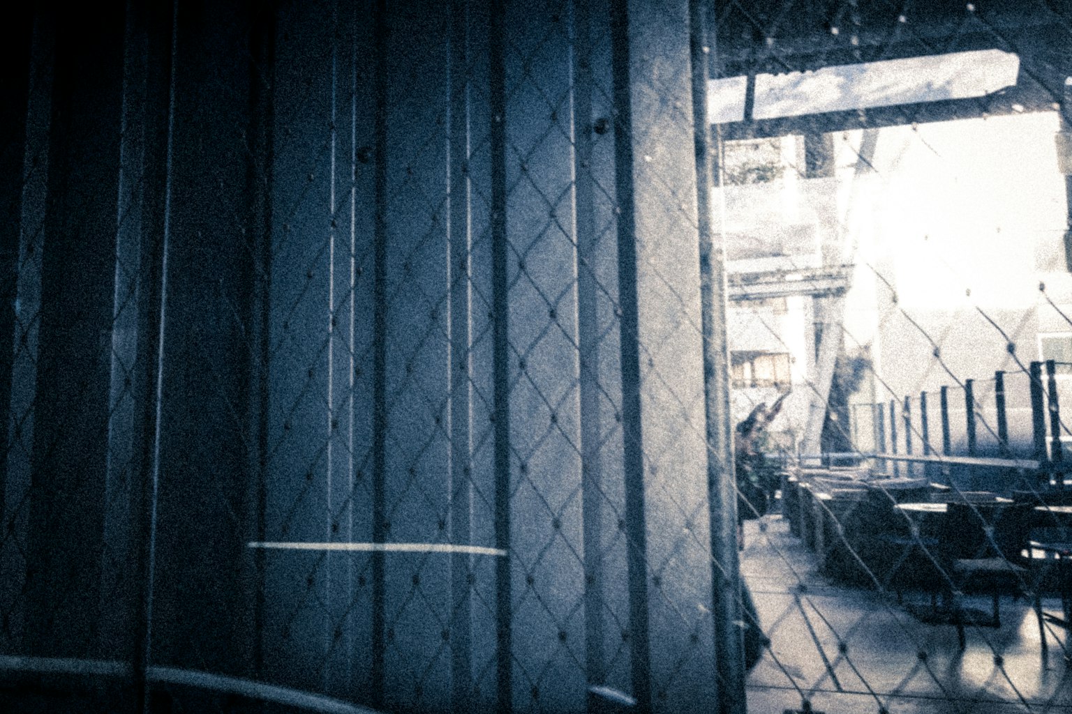 View of an industrial interior through a chain-link fence