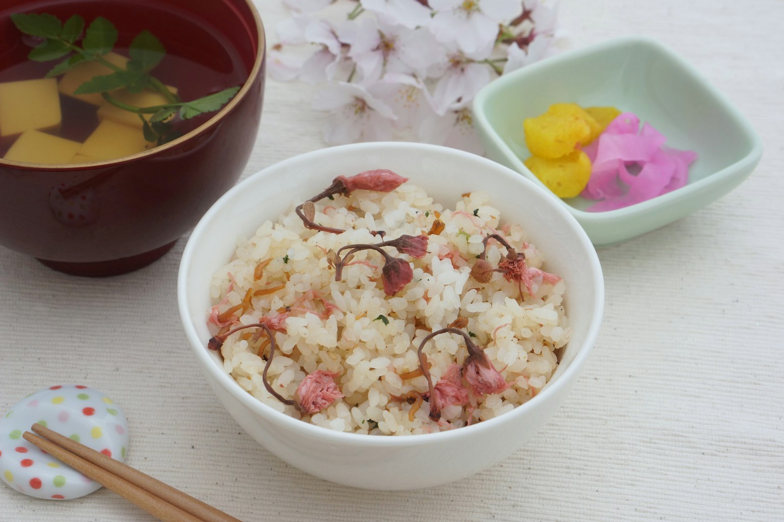 Riz assaisonné servi avec des fleurs de cerisier et une soupe claire