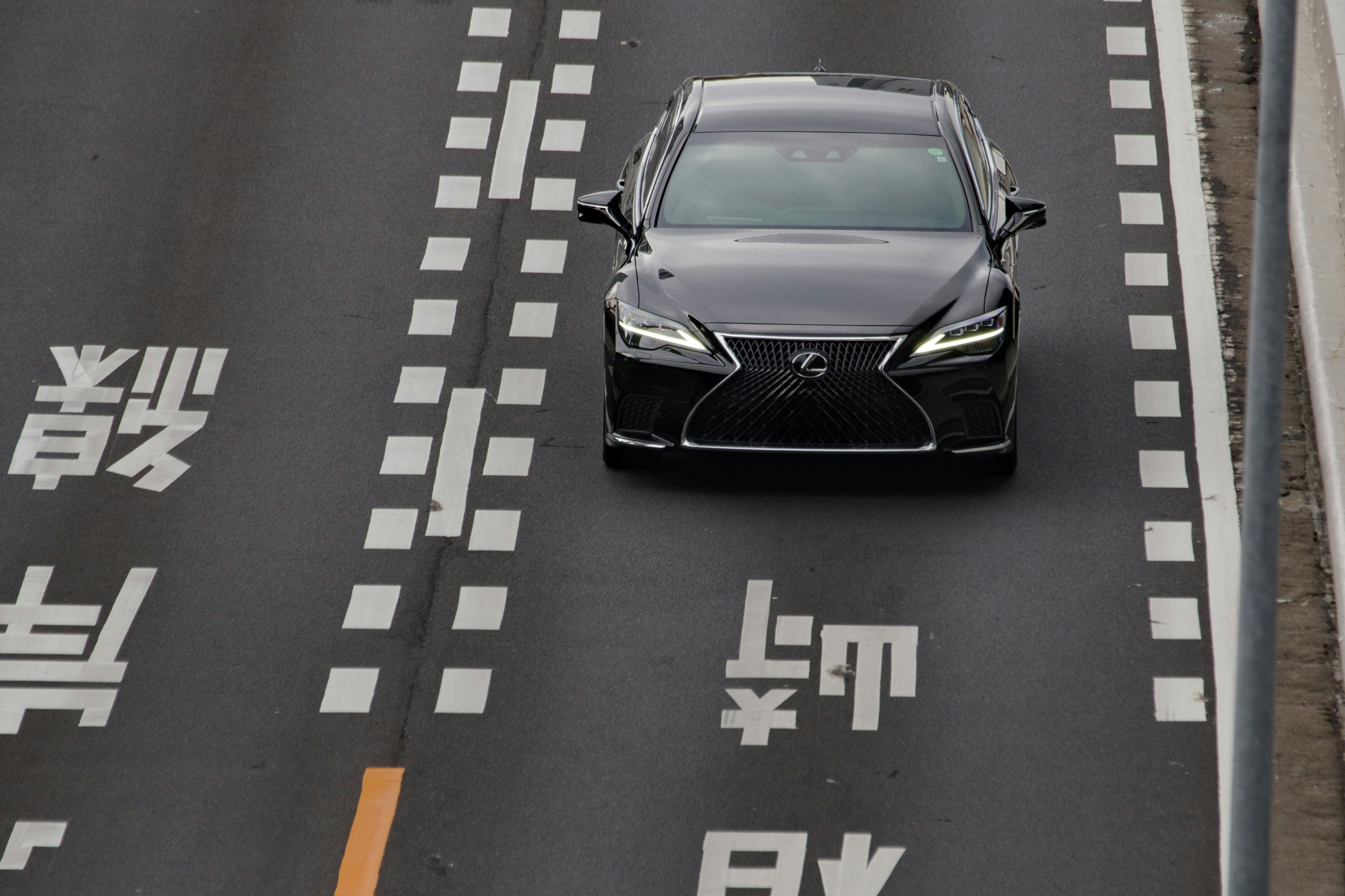 Voiture de luxe sur une route avec le logo LEXUS visible (TOYOTA)