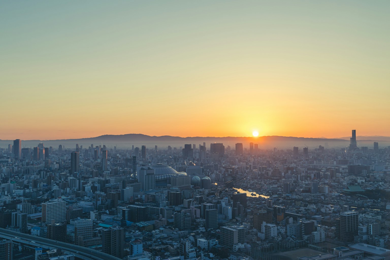 Pemandangan kota Tokyo saat matahari terbenam dengan gedung pencakar langit dan sungai