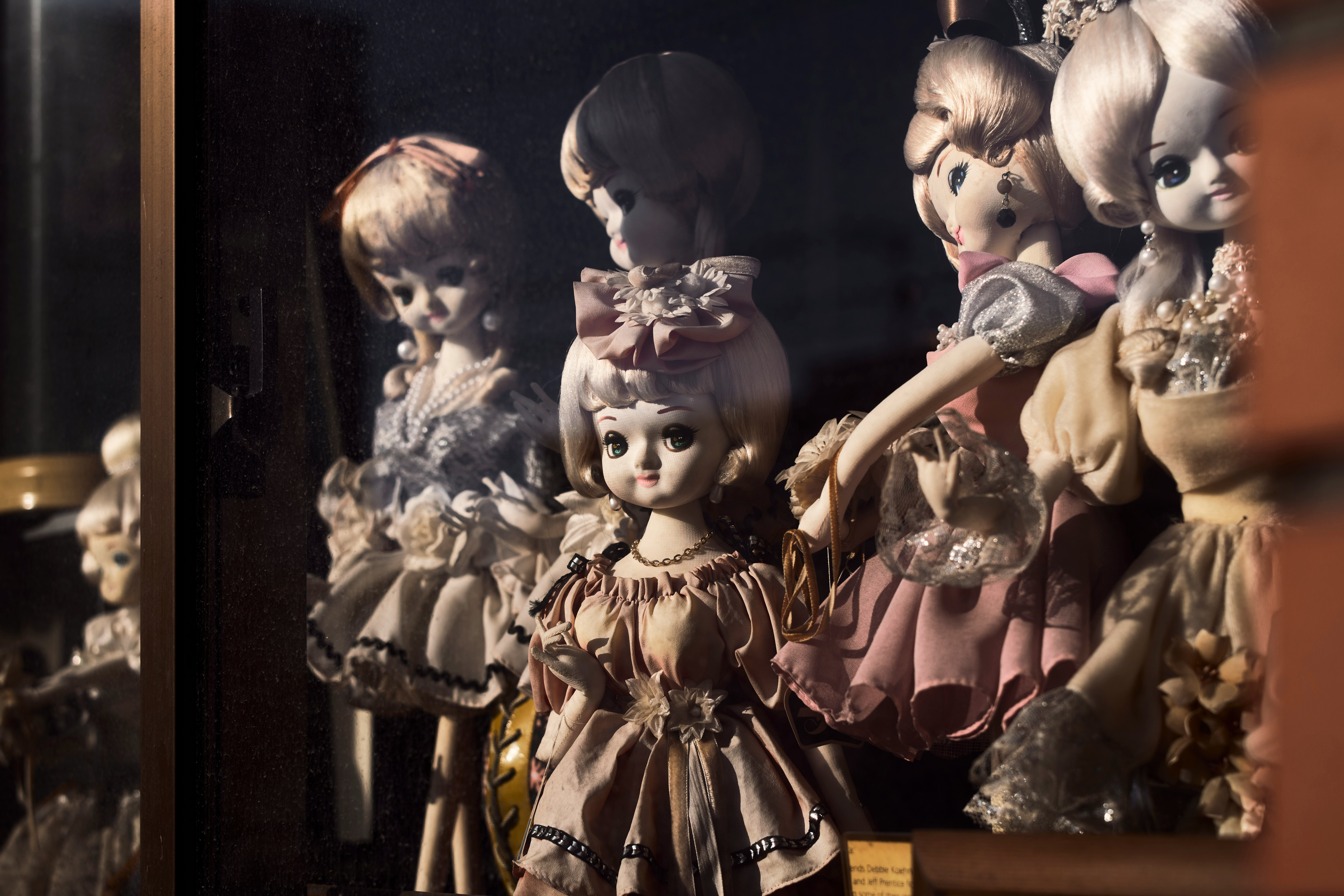 antique-style dolls lined up in a display case