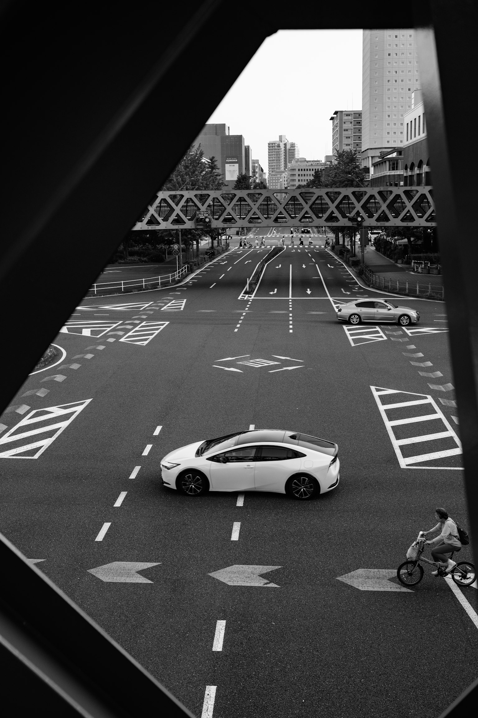 一輛白色汽車在單色城市風景中穿越十字路口